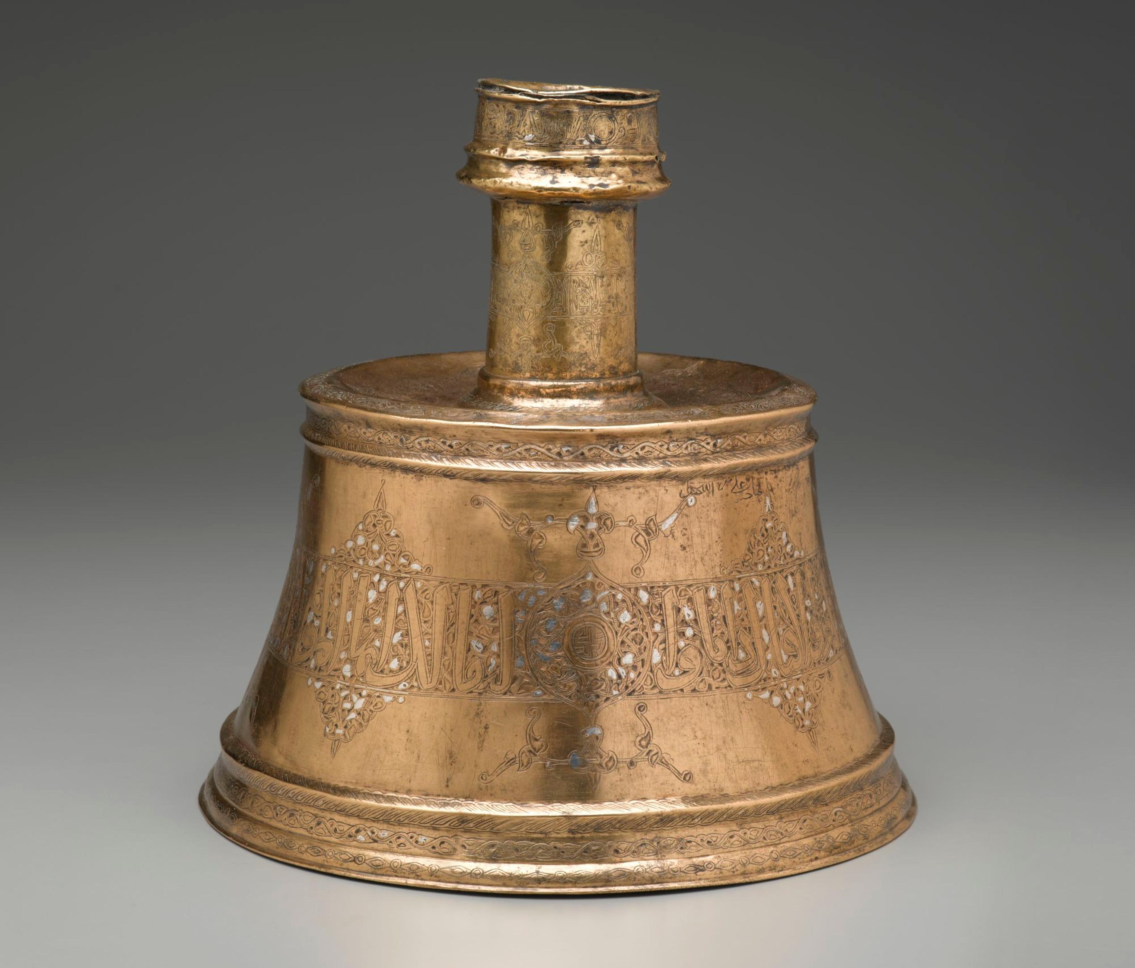 Candlestick, Egypt or Syria, Mamluk period, 14th century. Copper alloy; punched, engraved; inlaid with silver; h. 11 × 11 3/4 in. (27.9 × 29.8 cm). Brooklyn Museum, Gift of the Ernest Erickson Foundation, Inc., 86.227.197. (Photo: Brooklyn Museum)