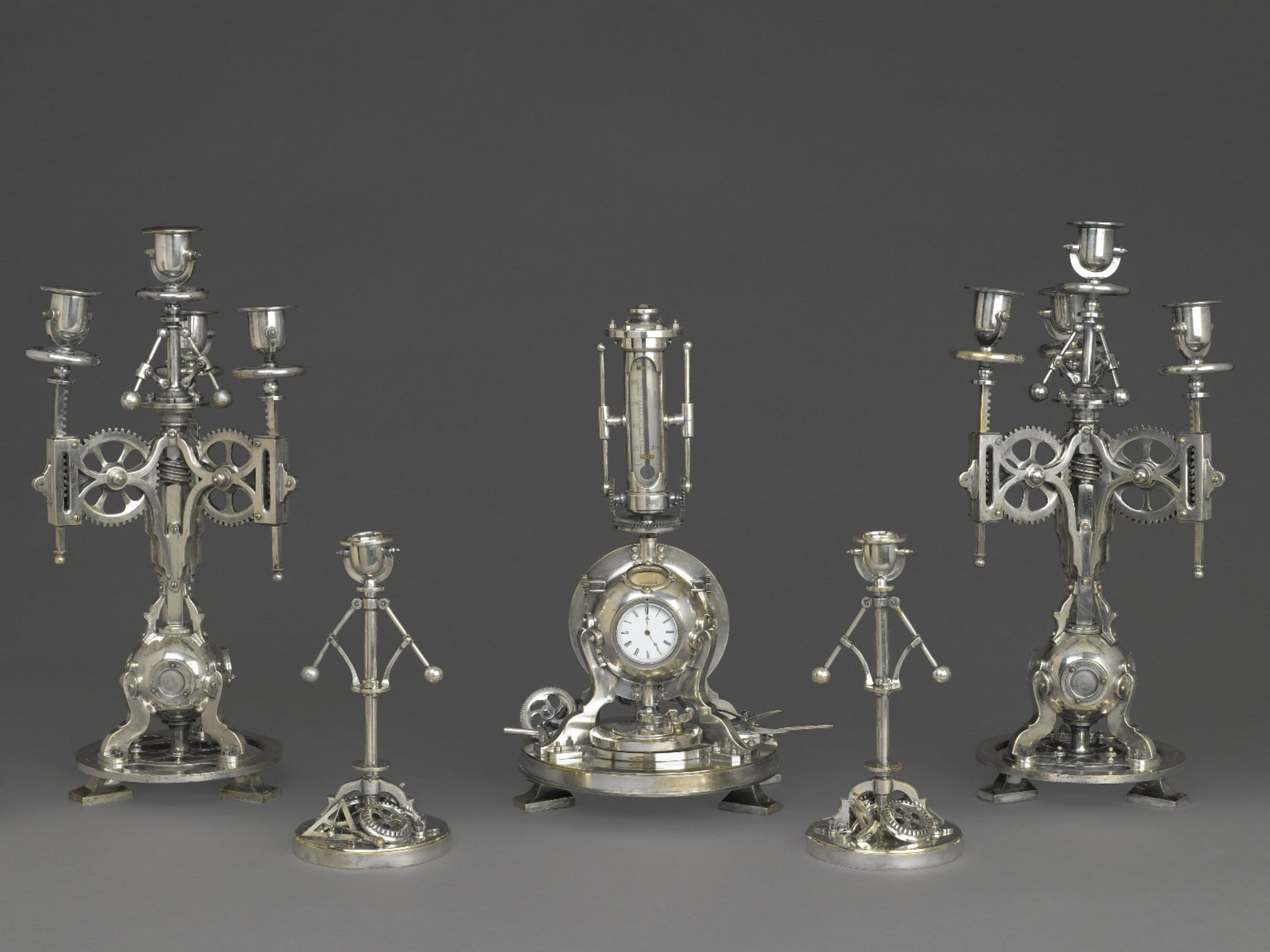 A mechanical-inspired silver candelabra set with intricate gear and machine motifs