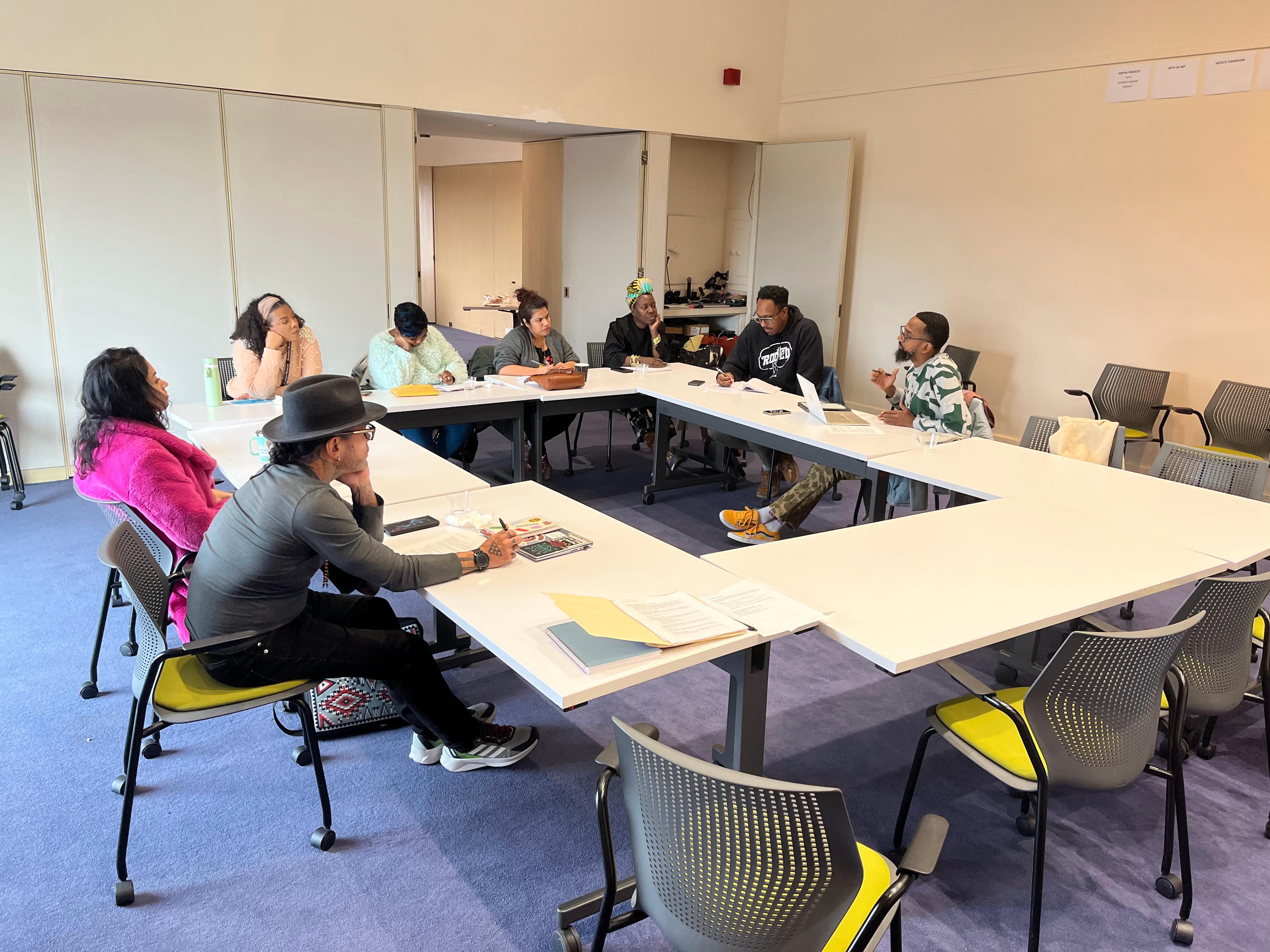 Eight adults sit around rectangular tables