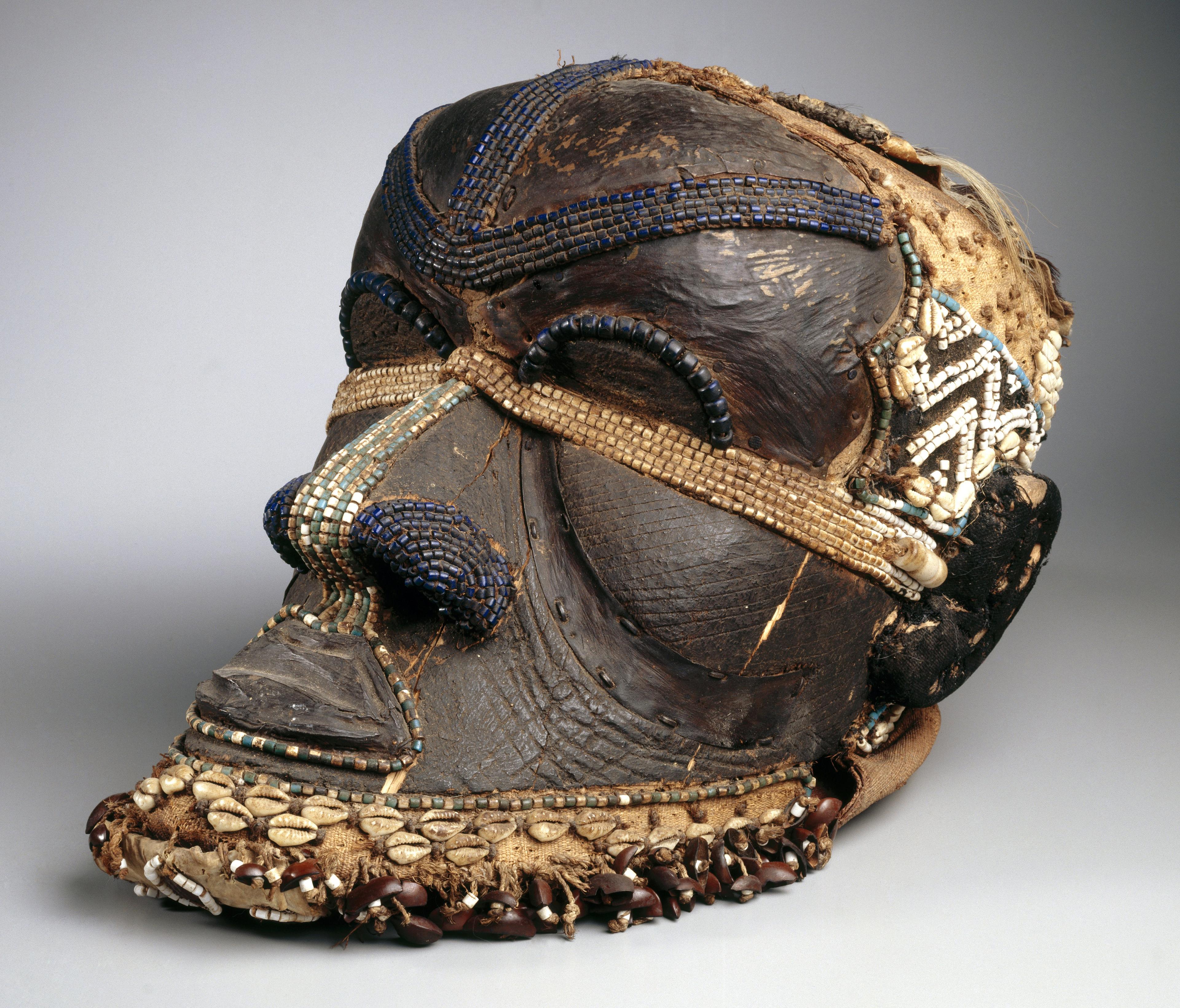 Kuba artist. Bwoom Mask, late 19th or early 20th century. West Kasai Province, Democratic Republic of the Congo. Wood, copper alloy, plant fiber, skin, cowrie shells, seedpods, glass beads, textile, pigments, 133/4 x 81/4 x 12 in. (35 x 21 x 30.5 cm). Gift of Mr. and Mrs. John McDonald, 73.178. (Photo: Brooklyn Museum)