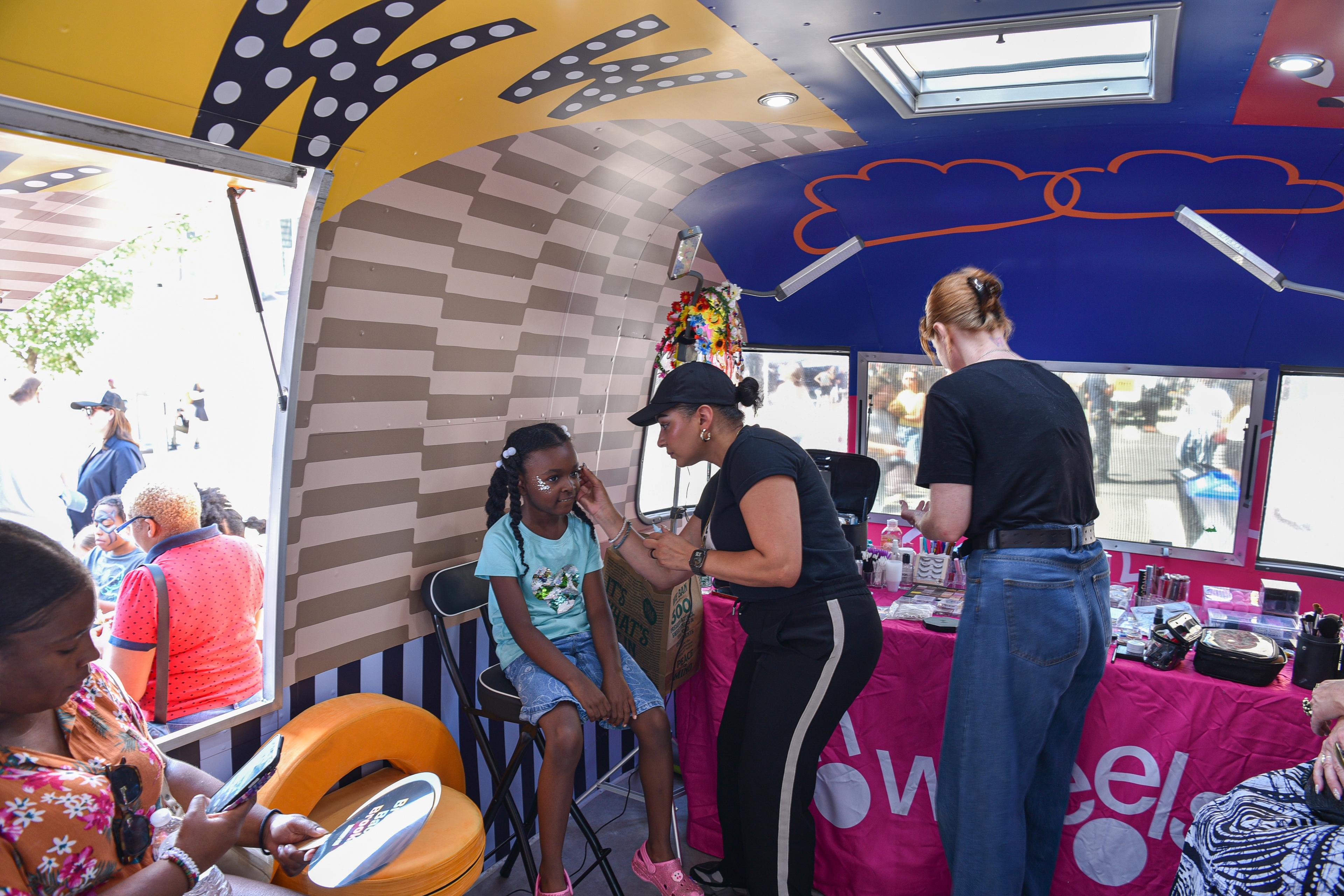 A child having their face painted inside an Airstream trailer