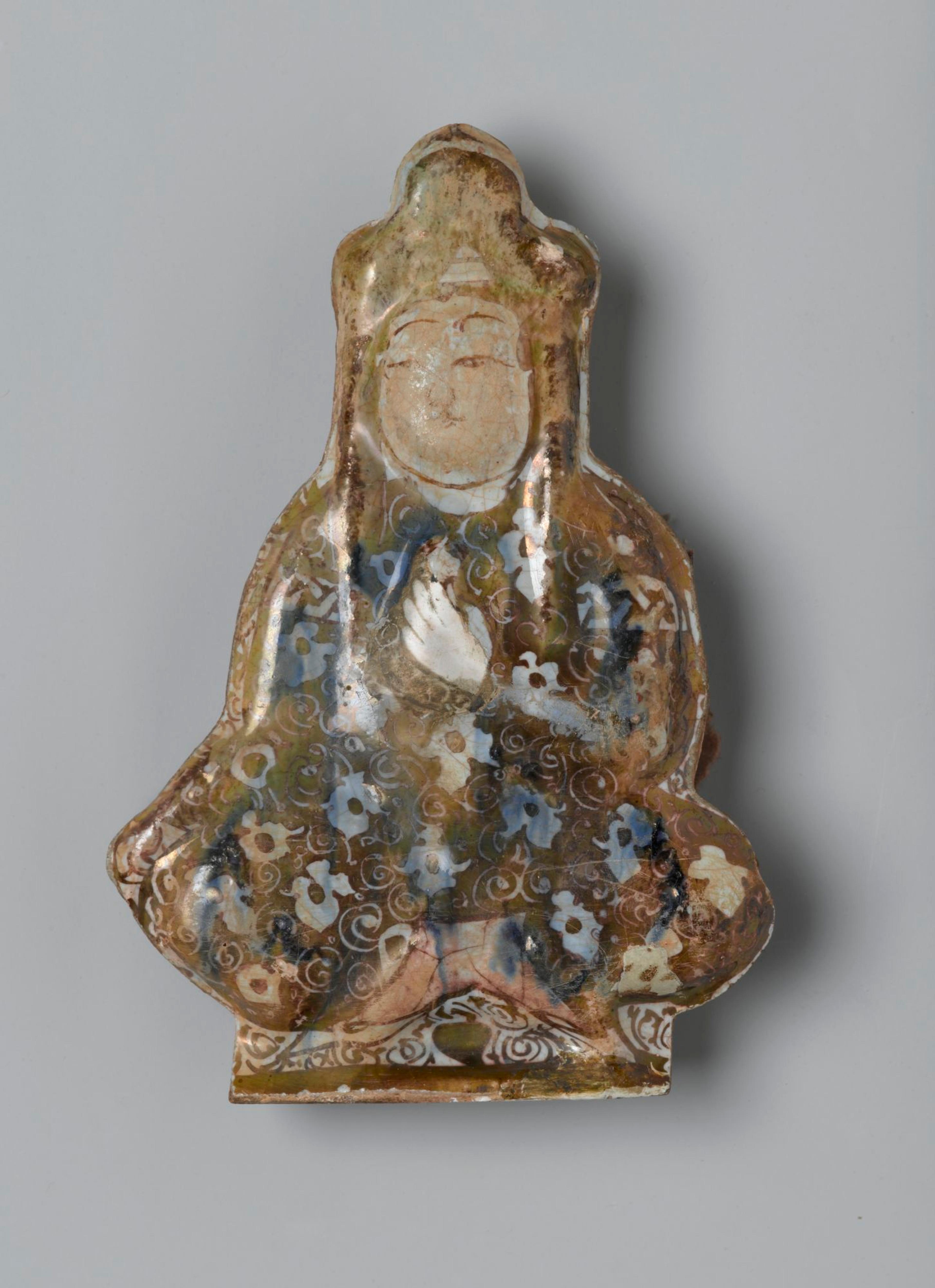 Tile in the Shape of a Seated Figure, Iran (probably Kashan), early 13th century. Ceramic; fritware, molded, underglaze painted, overglaze lustered, 5 1/2 × 4 in. (14 × 10.2 cm). Brooklyn Museum, Gift of the Ernest Erickson Foundation, Inc., 86.227.69. (Photo: Brooklyn Museum)