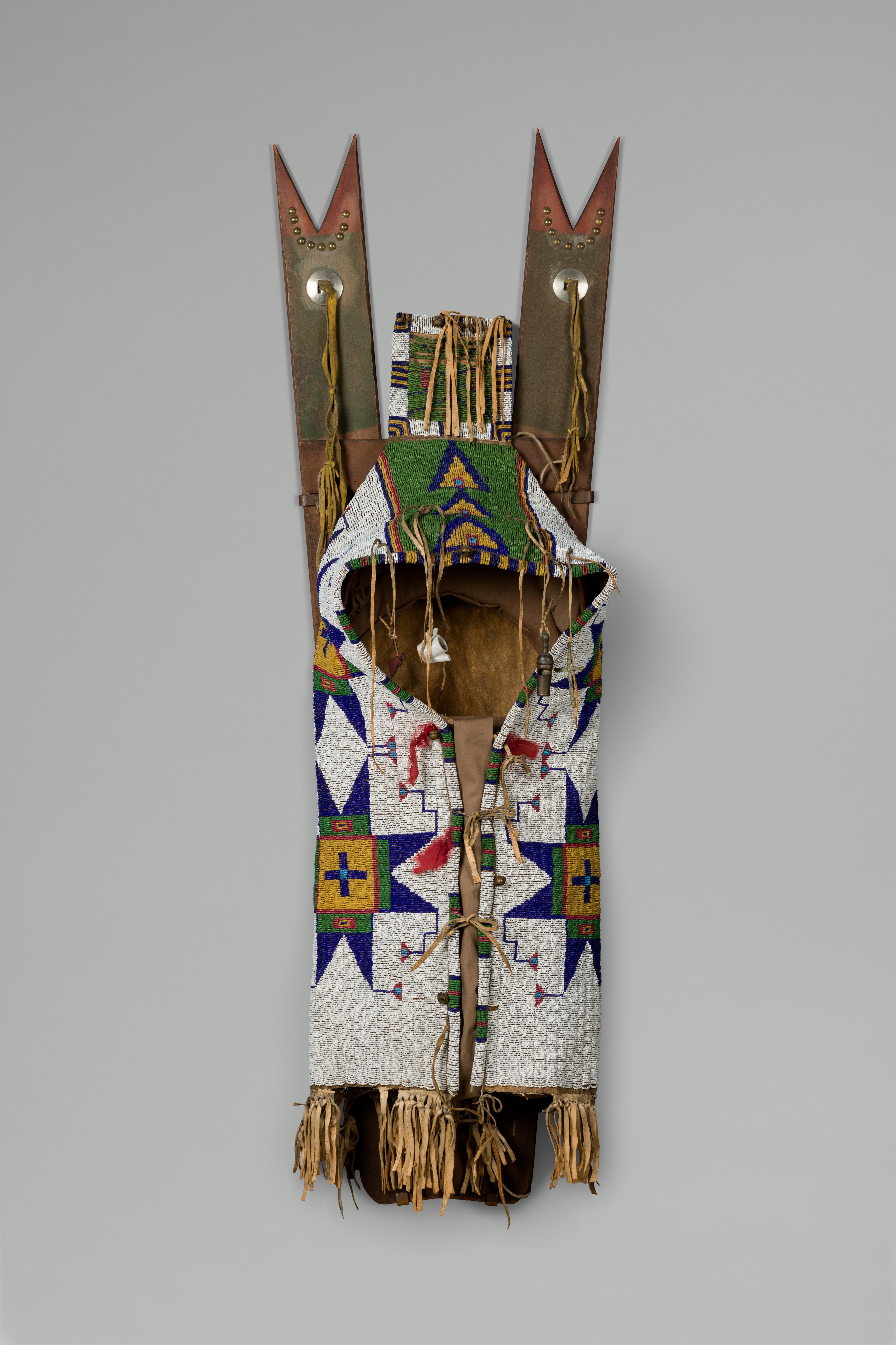 Očhéthi Šakówiŋ artist. <i>Cadleboard with Attached Toys</i>, 1870–1900. Buffalo hide, wood, glass beads, metal, ceramic, porcupine quills, brass nails, pigment. Dick S. Ramsay Fund, 38.630