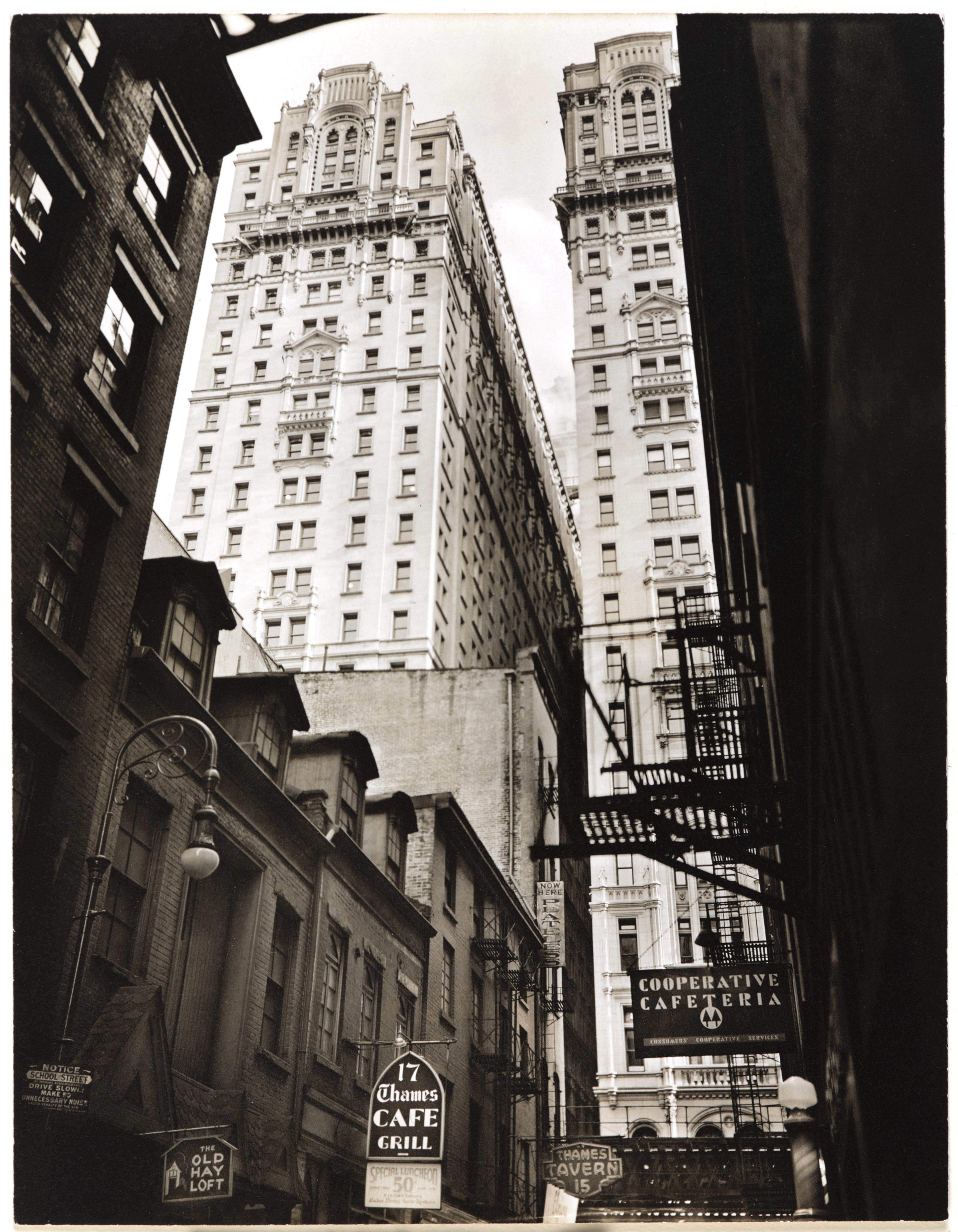 Black-and-white photograph looking up at Manhattan buildings