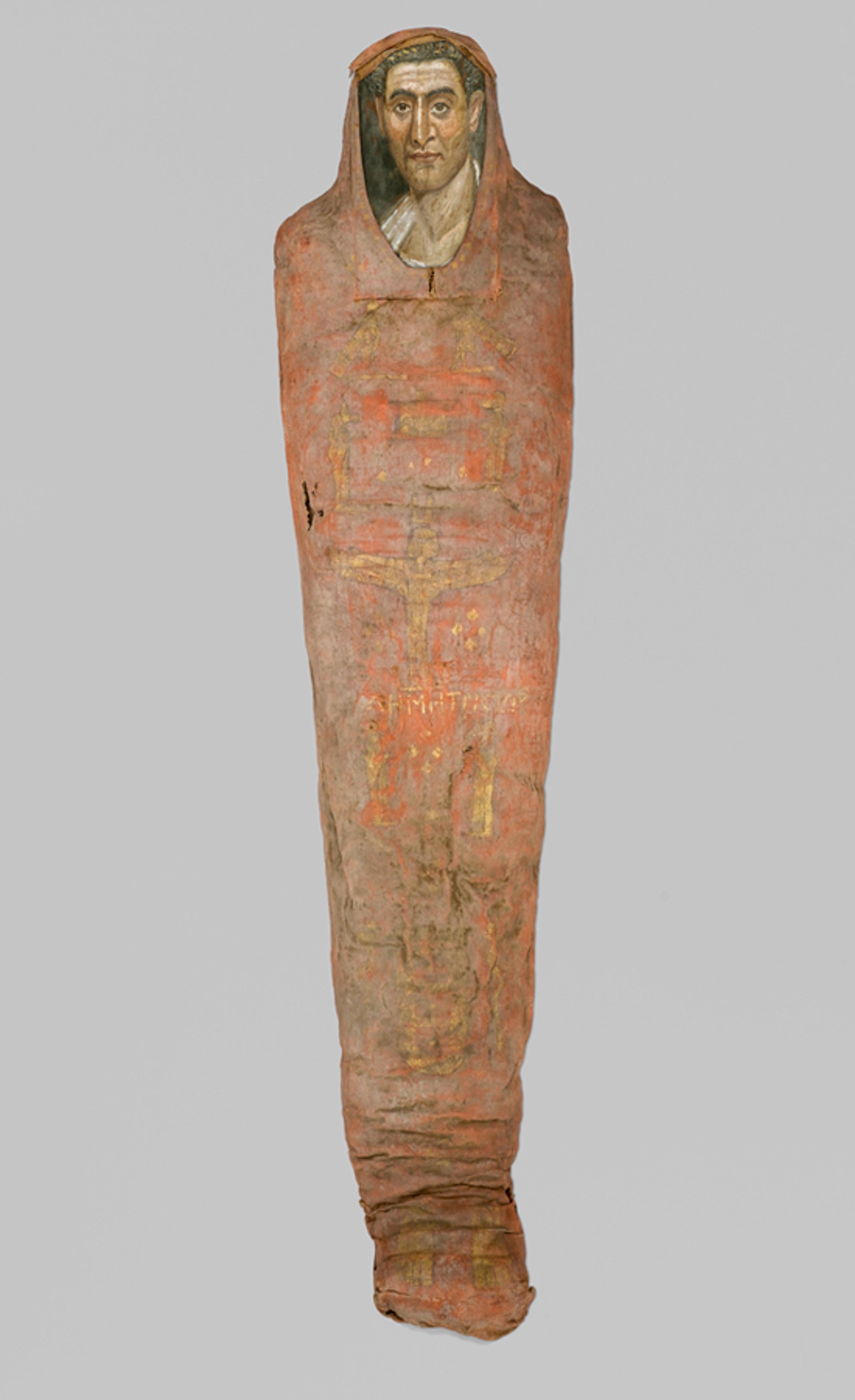 Mummy of Demetrios. Egypt, from Hawara. Roman Period. 95−100 C.E. Painted cloth, gold, human remains, wood, encaustic, gilding, 133⁄8 x 153⁄8 x 7413⁄16 in (34 × 39 × 190 cm), portrait: 14 11/16 × 8 1/16 × 1/16 in. (37.3 × 20.5 × 0.2 cm). Brooklyn Museum, Charles Edwin Wilbour Fund, 11.600a−b