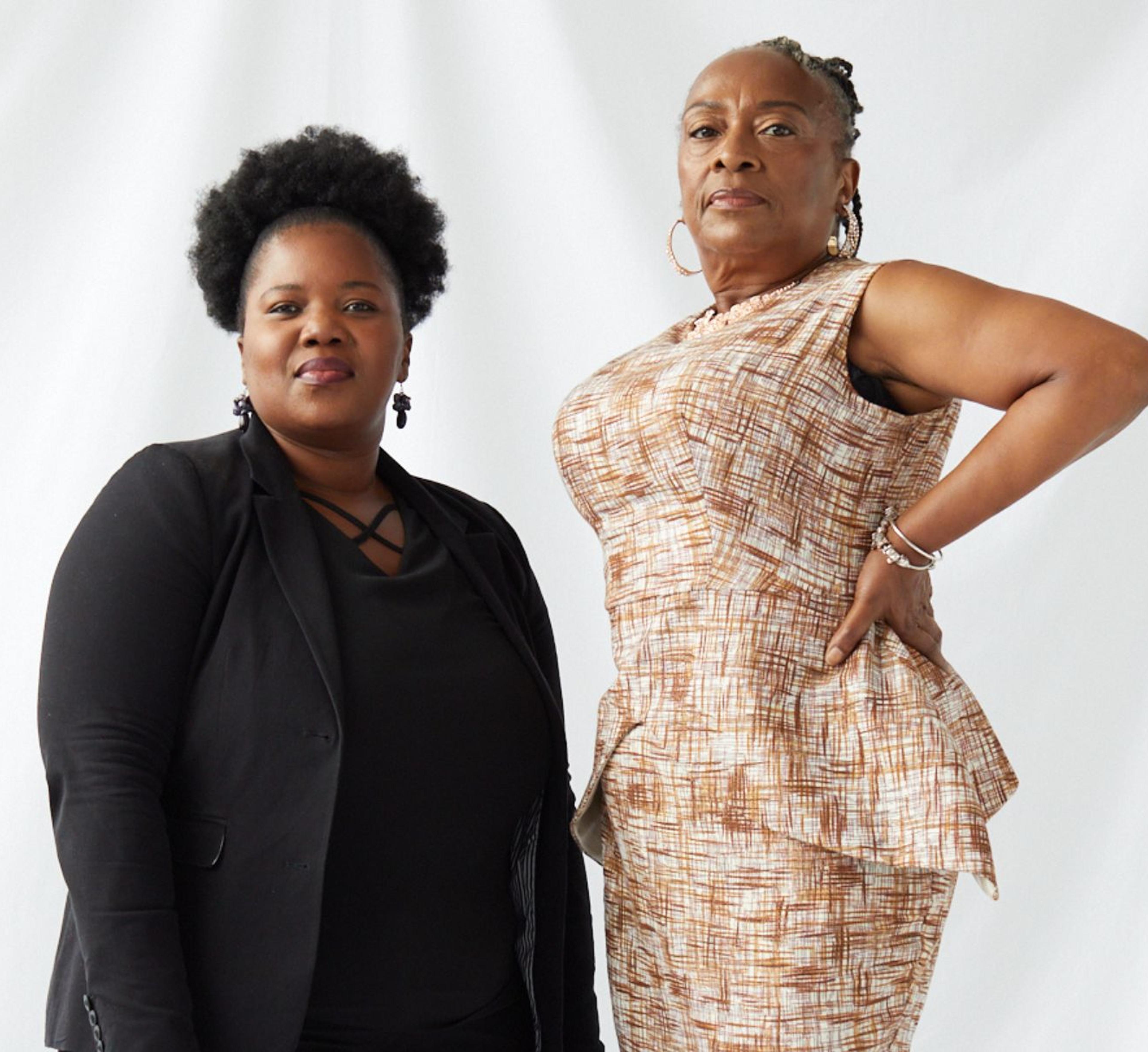 Two adults pose against a white backdrop