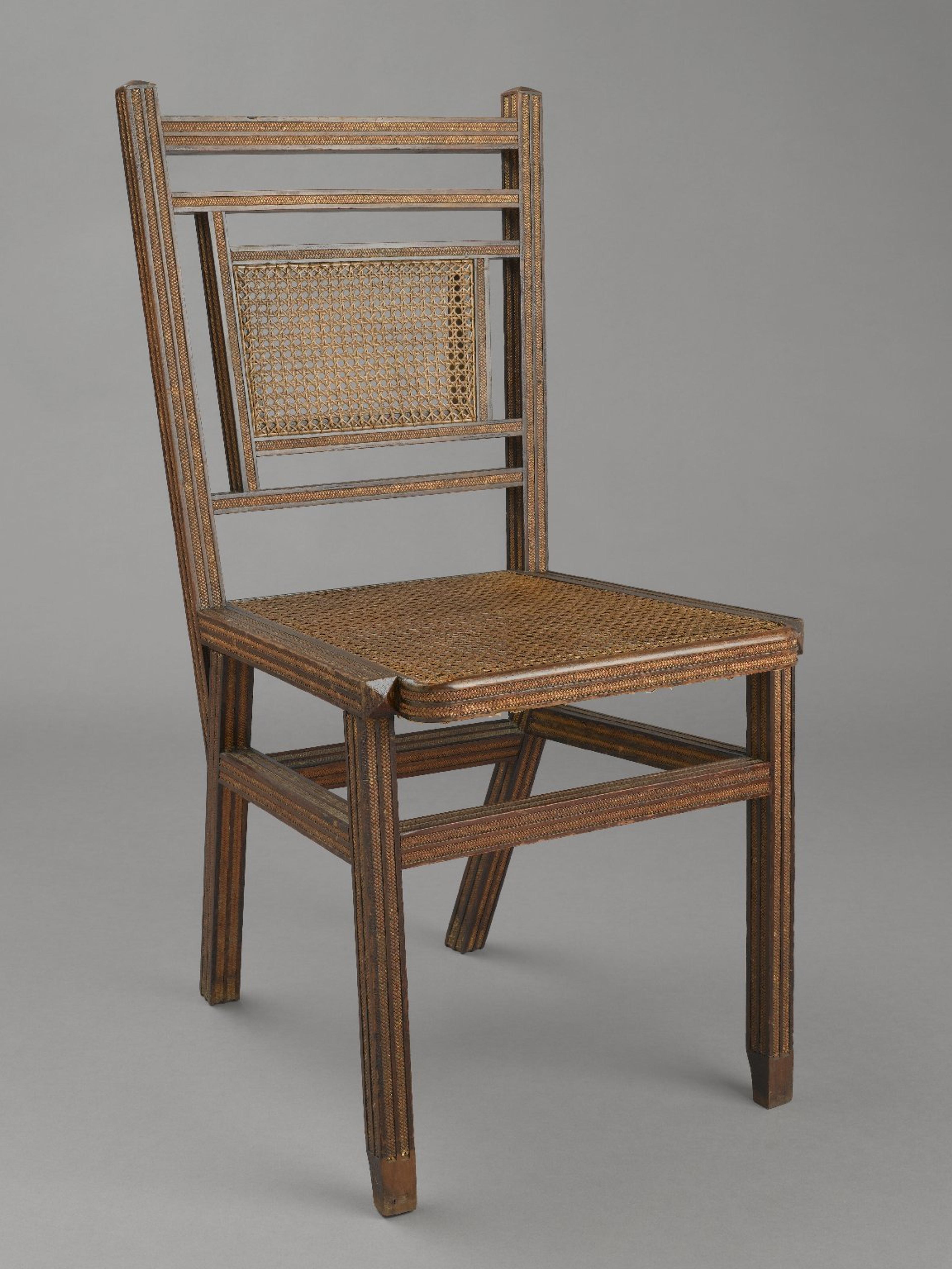 A simple wooden chair with a woven cane seat and backrest