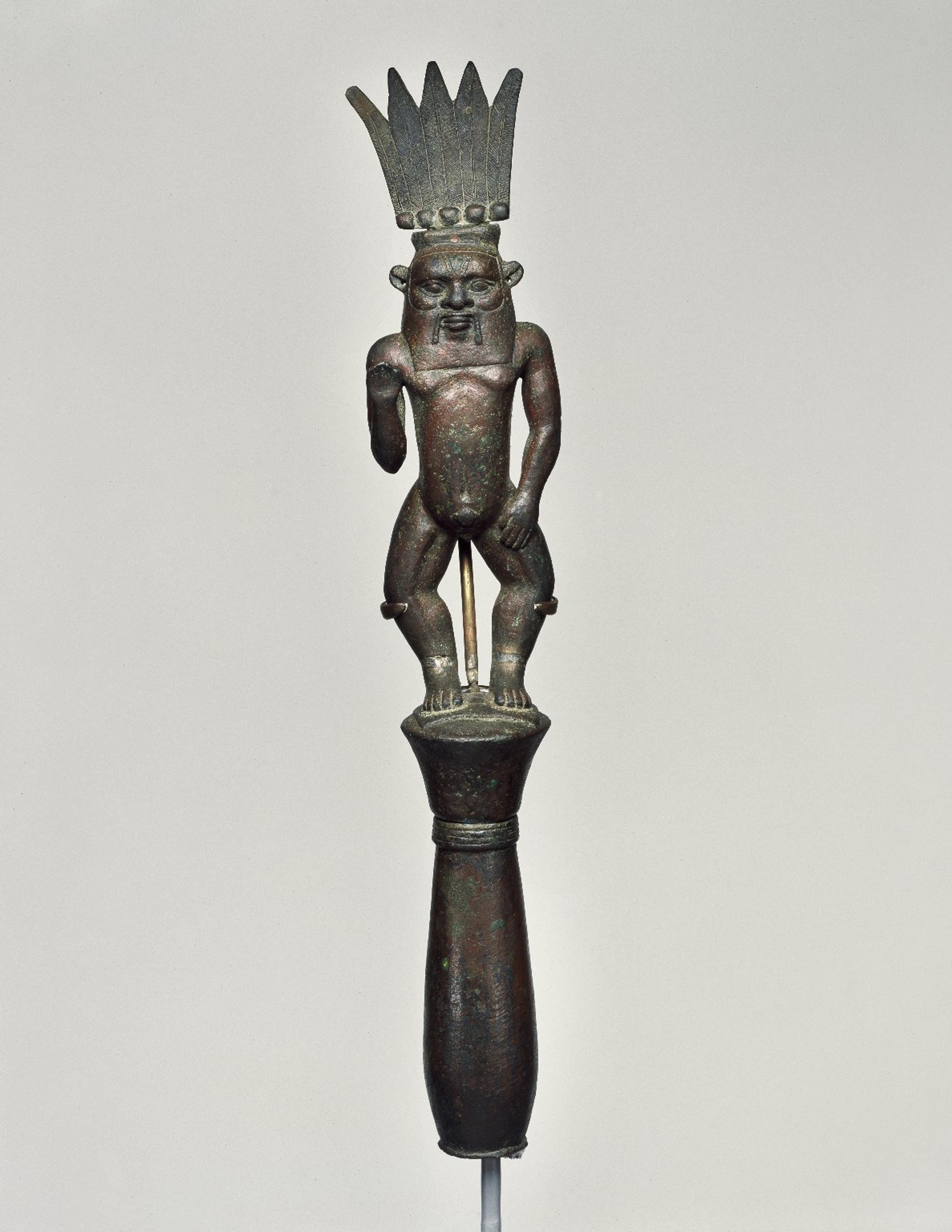 Finial with Figure of the God Bes. Third Intermediate Period, Dynasty 21 to Dynasty 25, circa 1075–656 B.C.E. Bronze,1515⁄16 x 213⁄16 in. (40.5 × 7.2 cm). Brooklyn Museum, Charles Edwin Wilbour Fund, 46.127