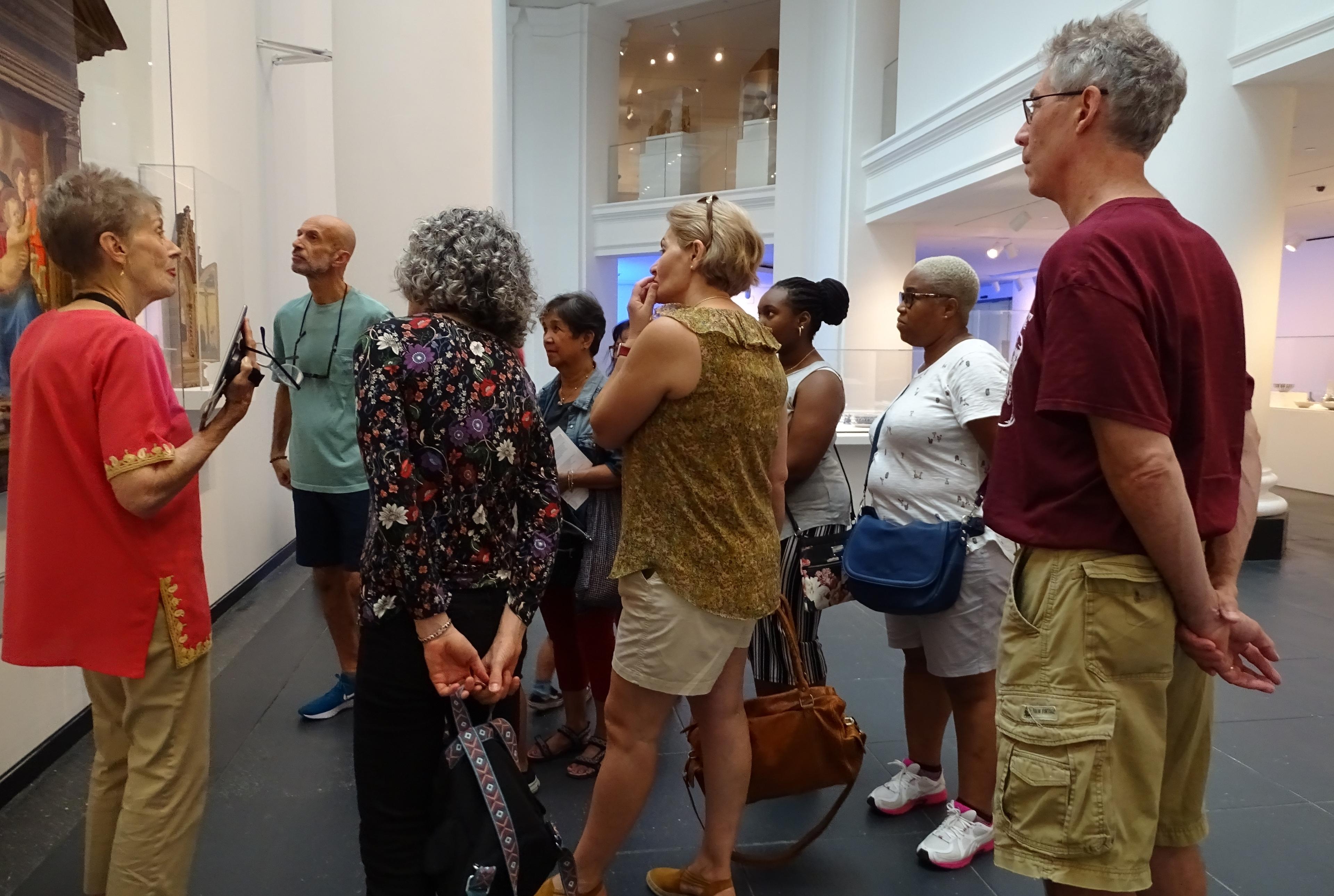 A group of adults listens to a guide on a tour of the Brooklyn Museum galleries