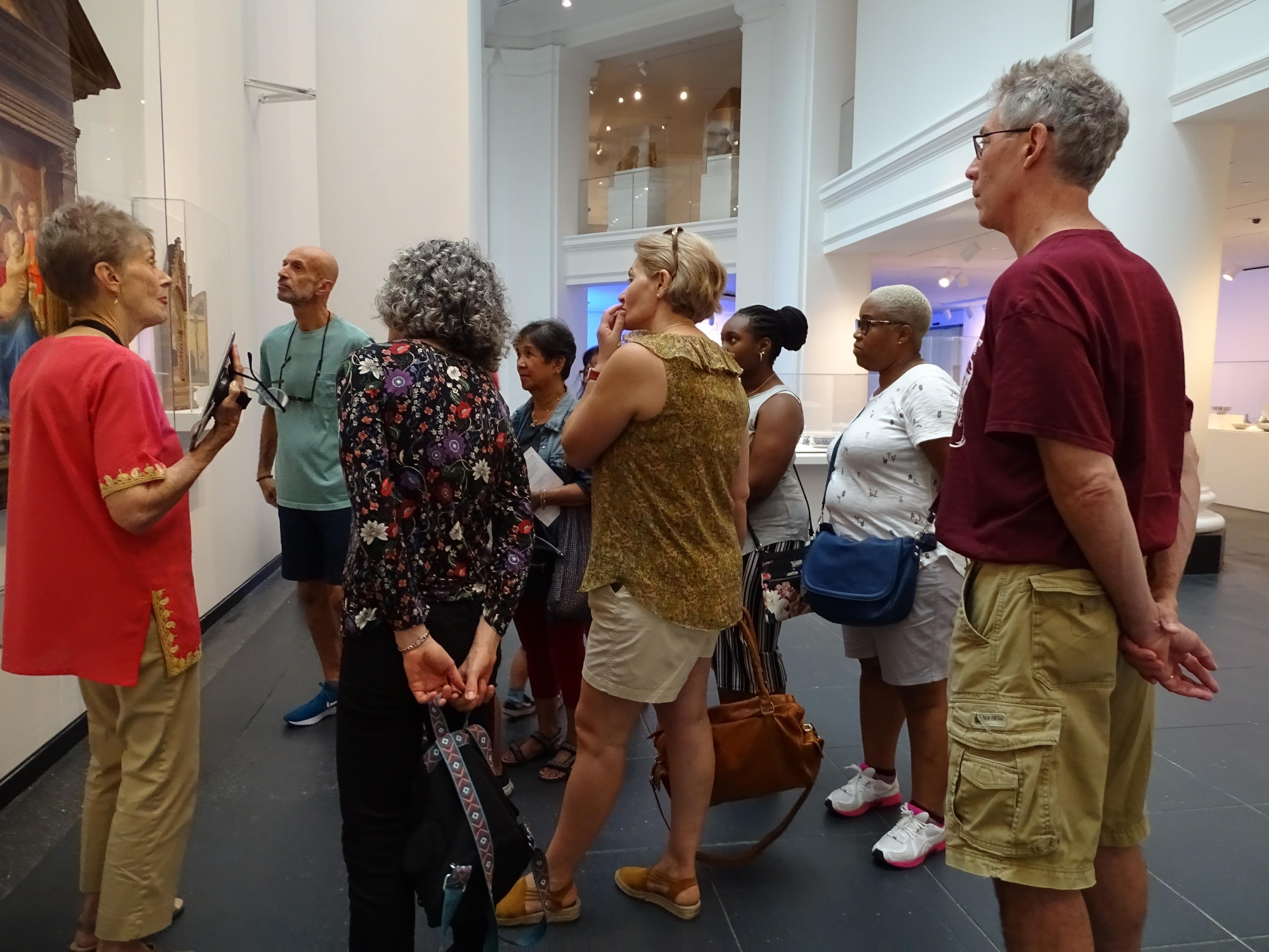 A group of adults listens to a guide on a tour of the Brooklyn Museum galleries