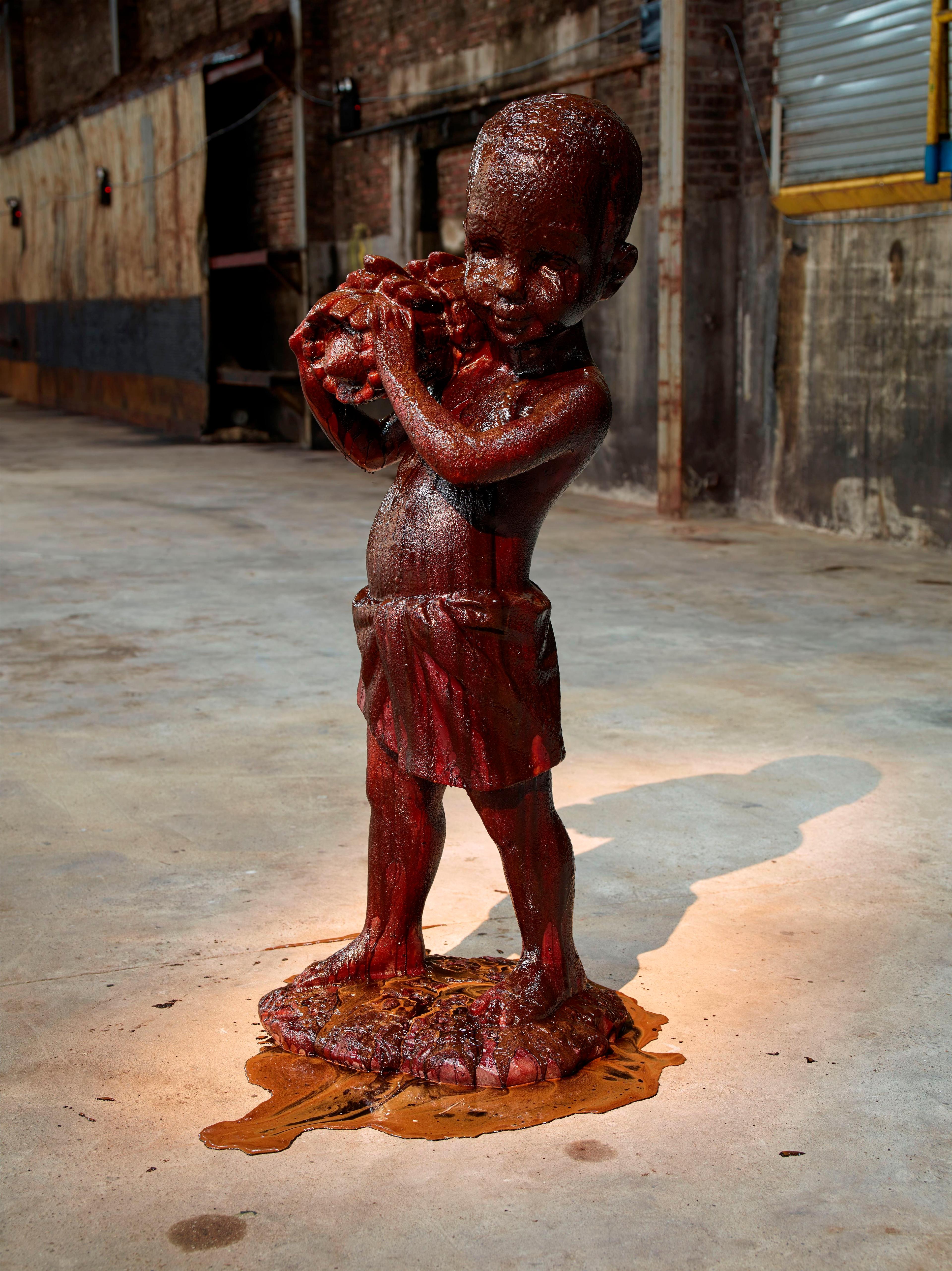 Kara Walker (American, b. 1969). African Boy Attendant Curio with Molasses and Brown Sugar, from “The Marvelous Sugar Baby” Installation at the old Domino Sugar Factory Warehouse (Bananas), 2014. Cast pigmented polyester resin with polyurethane coating with molasses and brown sugar, 591⁄2 x 20 × 19 in. (151.1 × 50.8 × 48.3 cm). Edition of 5. © Kara Walker. (Photo: Jason Wyche)