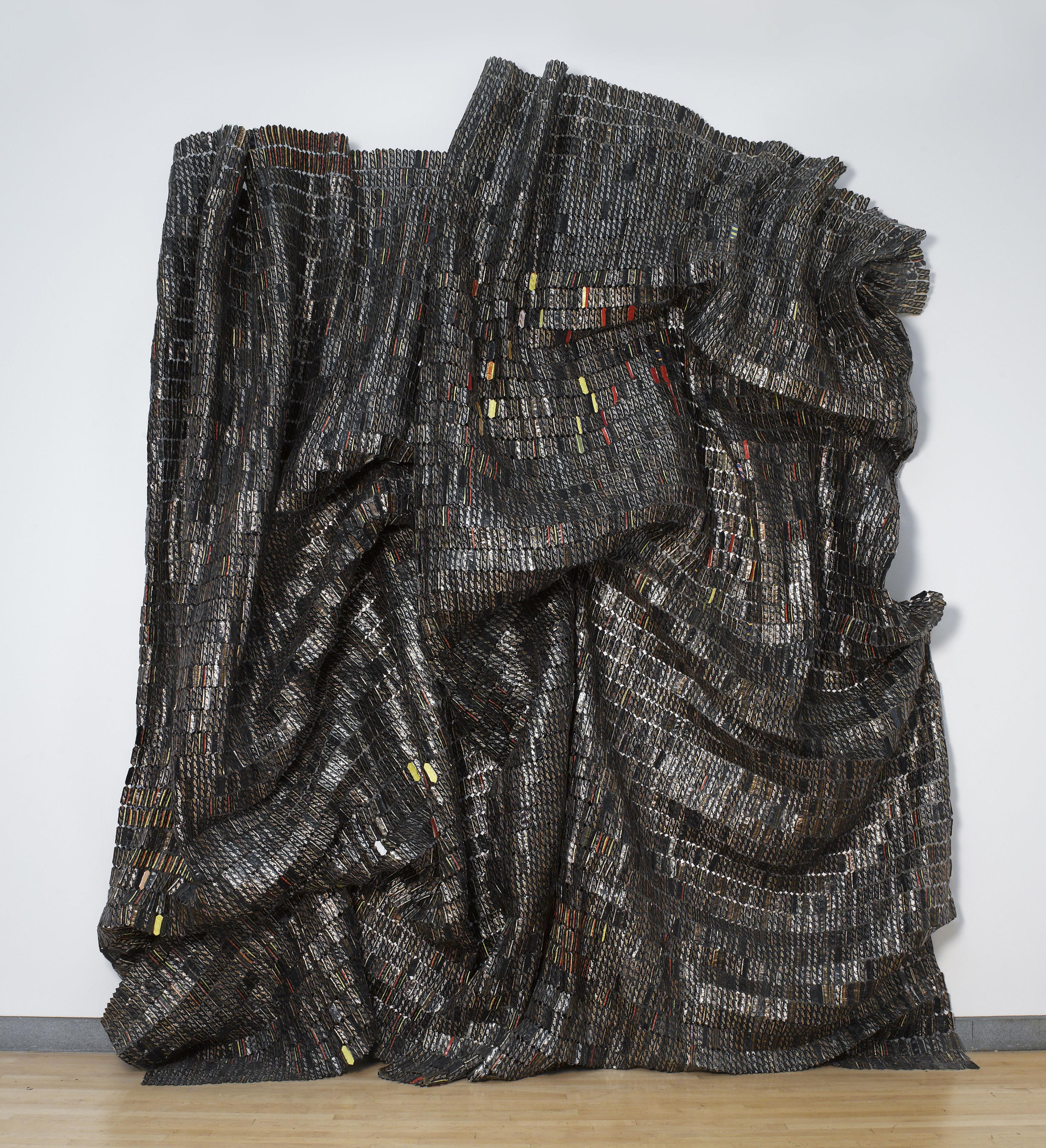 Glistening, cascading sculpture constructed with bottle tops and copper wire