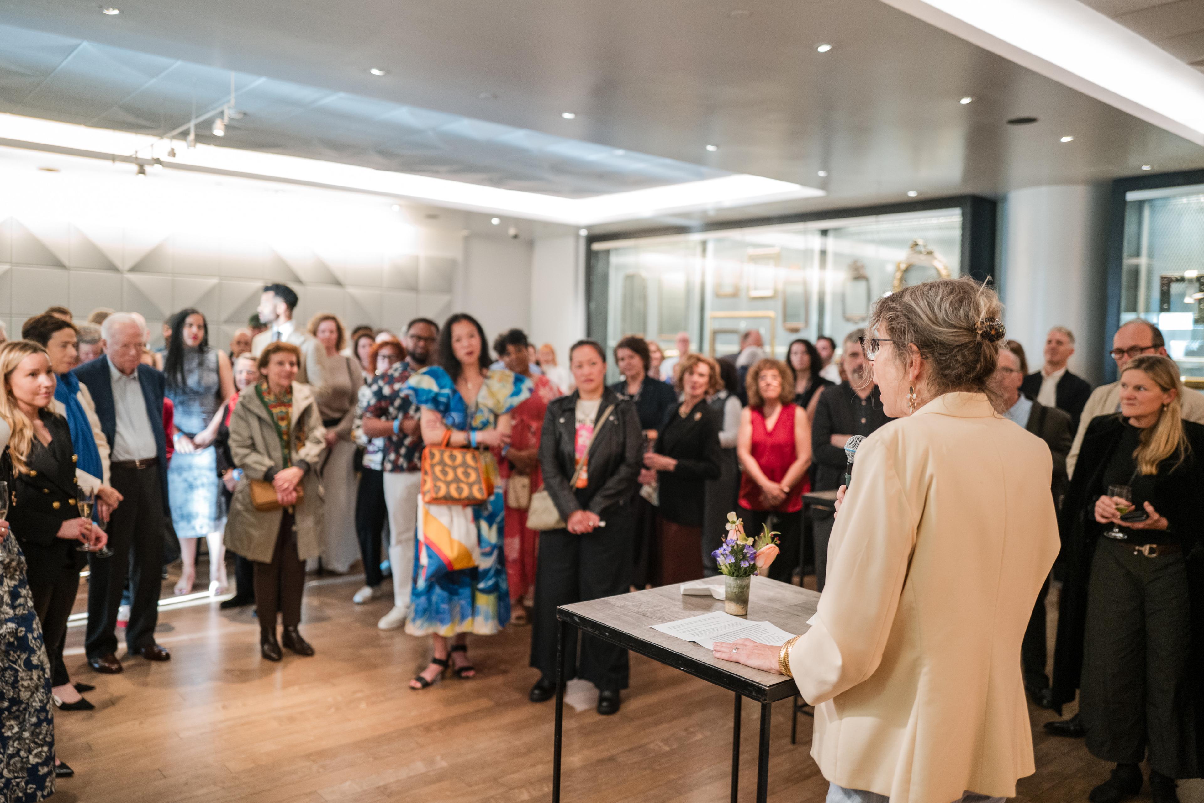 A person gives remarks to a room full of attendees