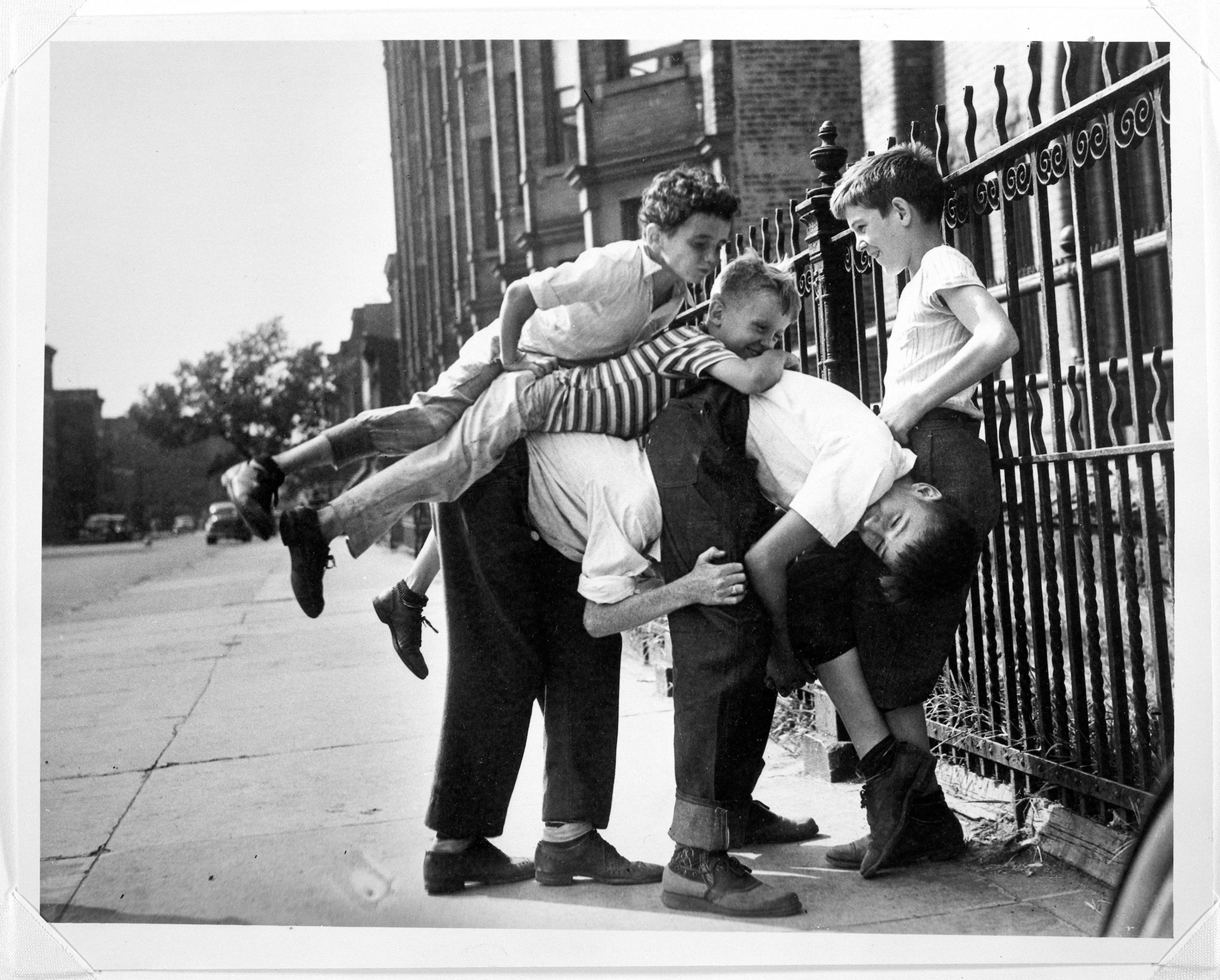 A black-and-white photograph of children playing on a city street