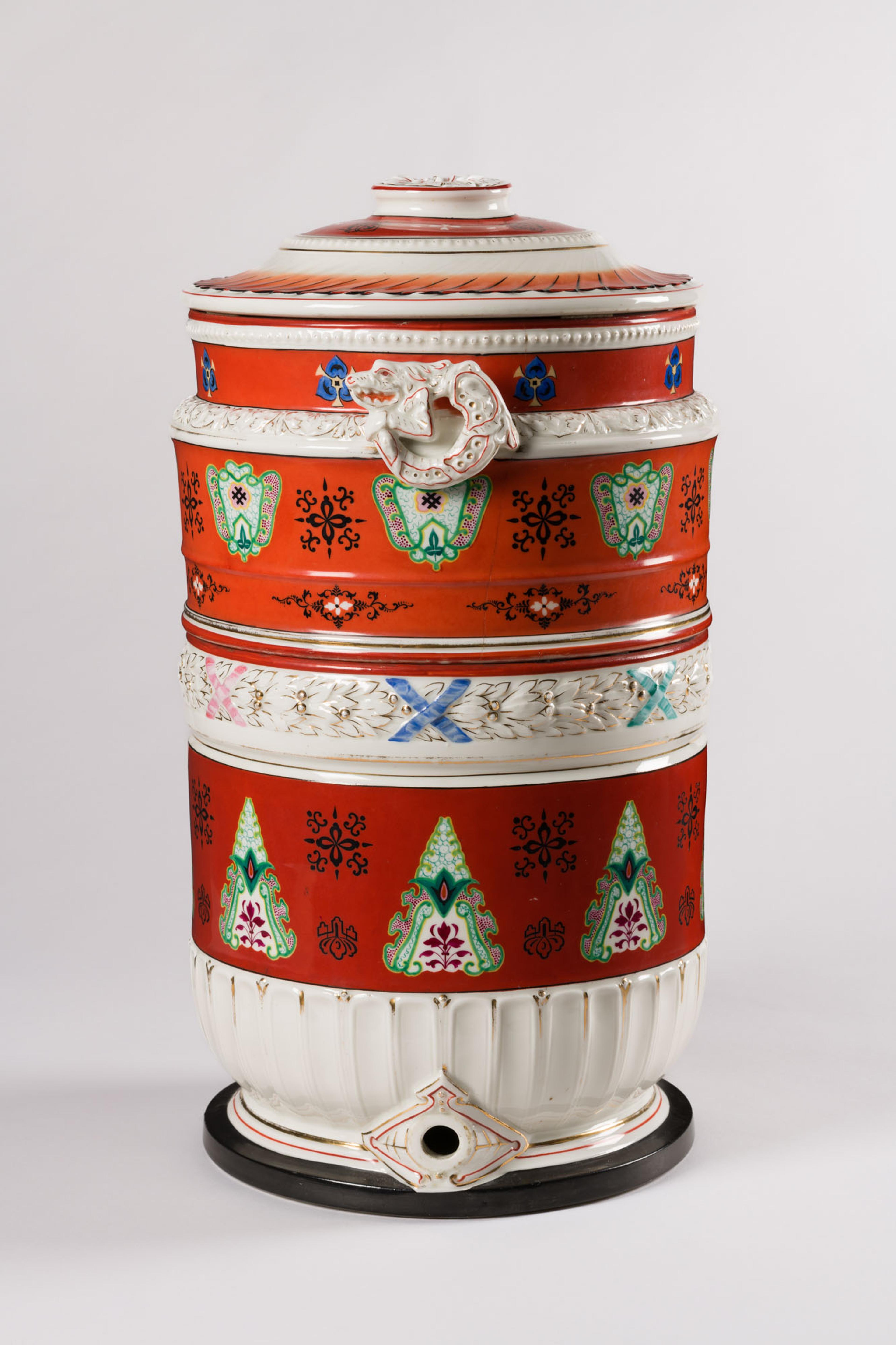 Tall cylindrical vessal with red and white stripes and coloraful floral decorations