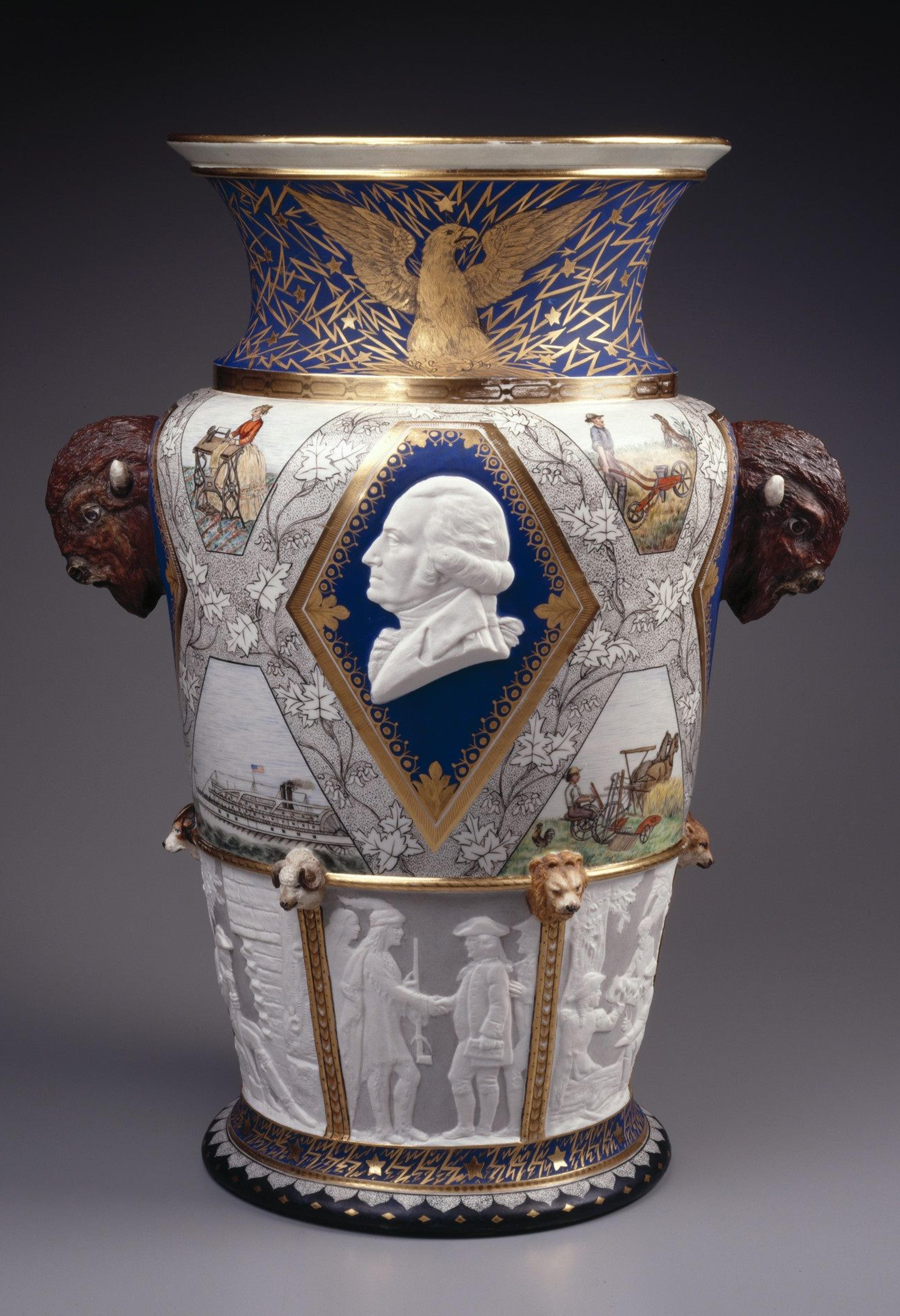 Large, elaborately decorated ceramic vase featuring the face of George Washington, heads of bison, and scenes of American history