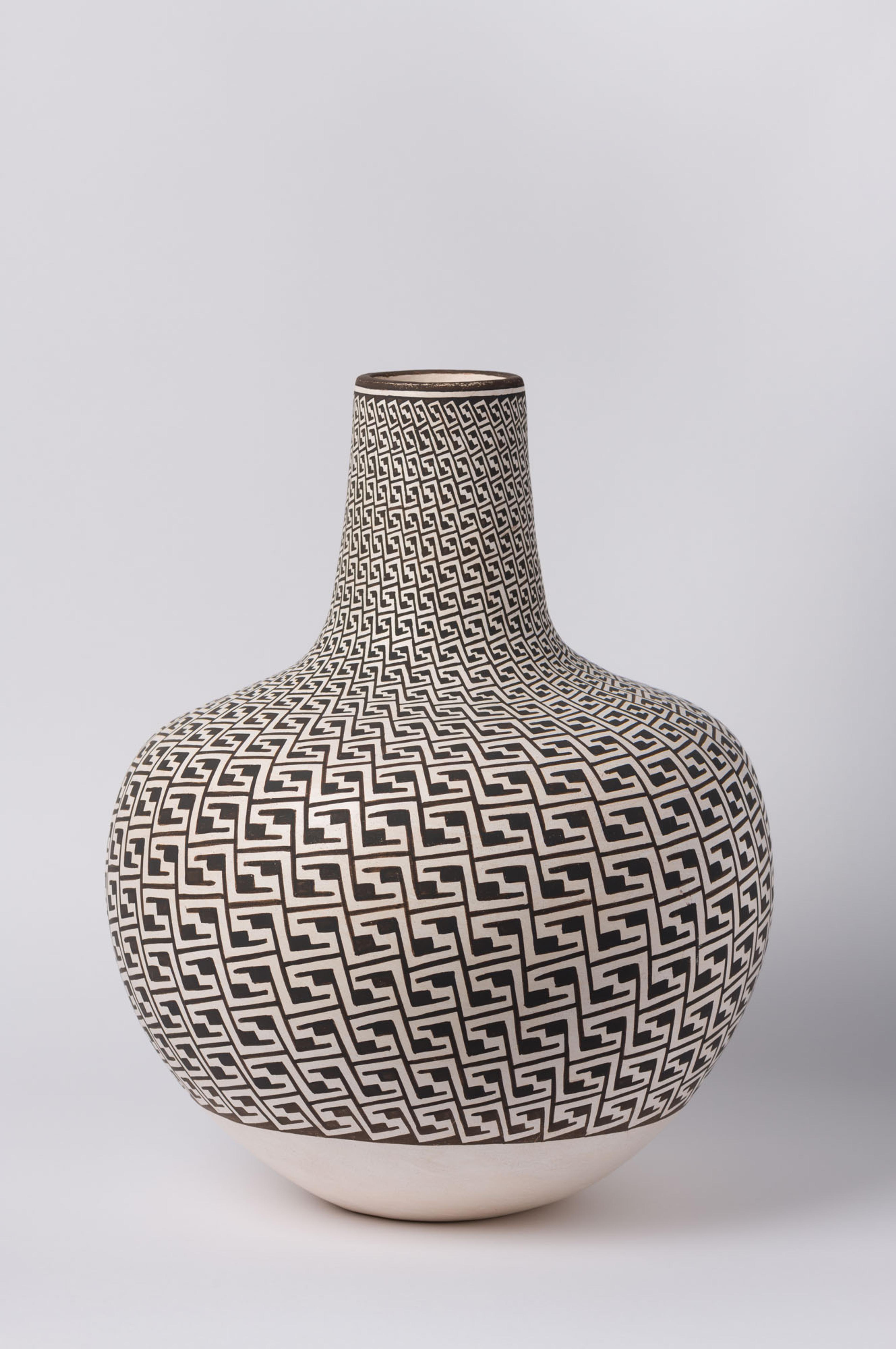 Photo of a vase with  a narrow neck and large round base, decorated with black and white graphic pattern