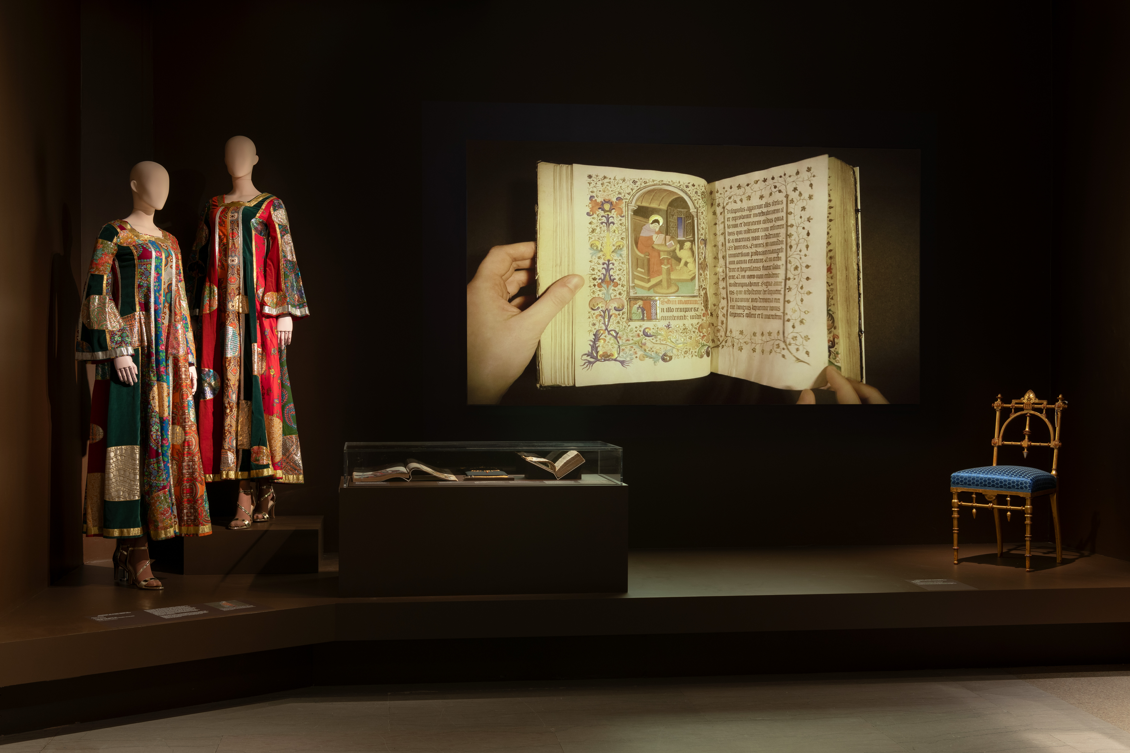 A gallery view with fashion and a close-up of a manuscript