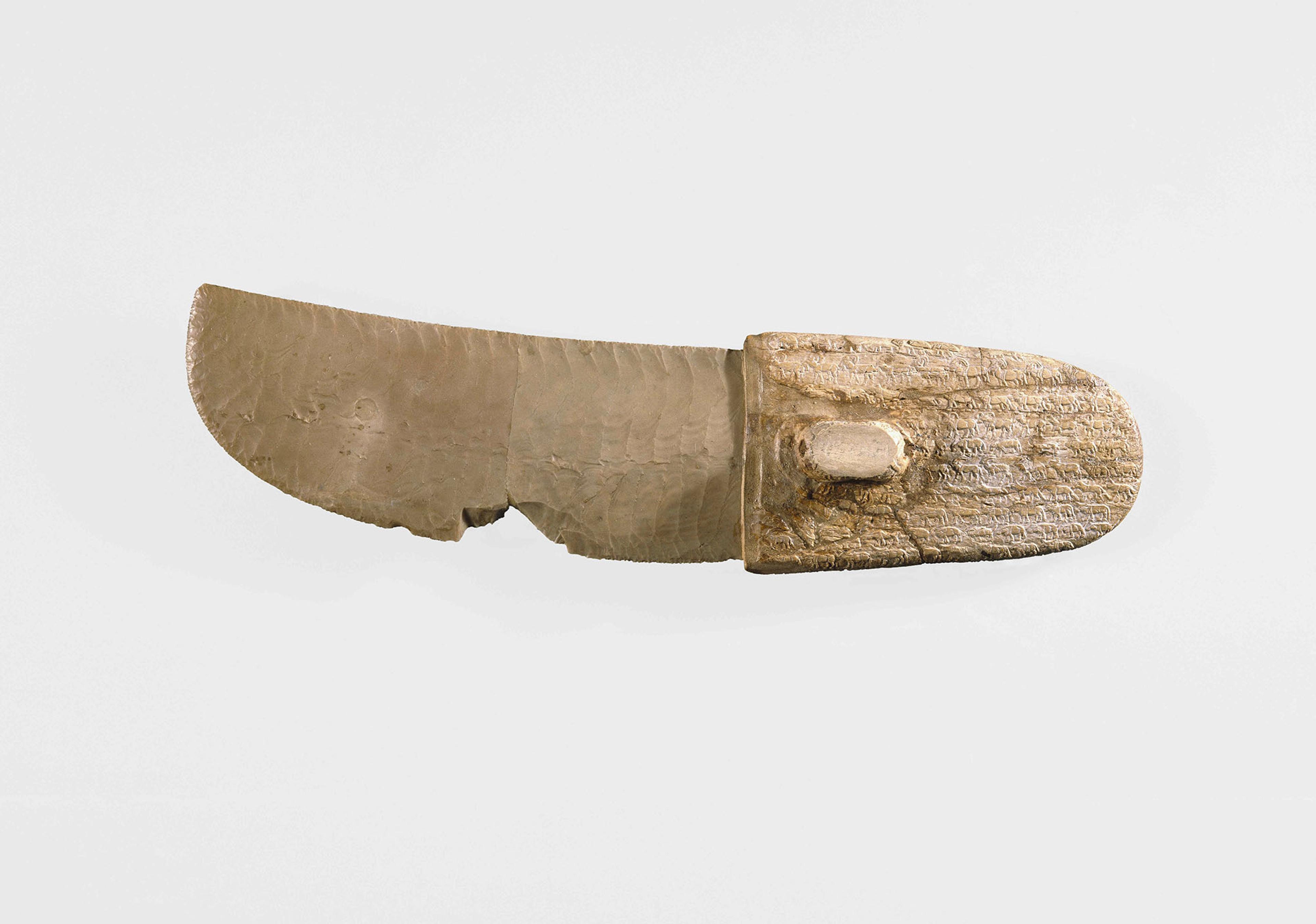 Ancient knife with a flint blade and ivory handle decorated with hundreds of tiny carved animals