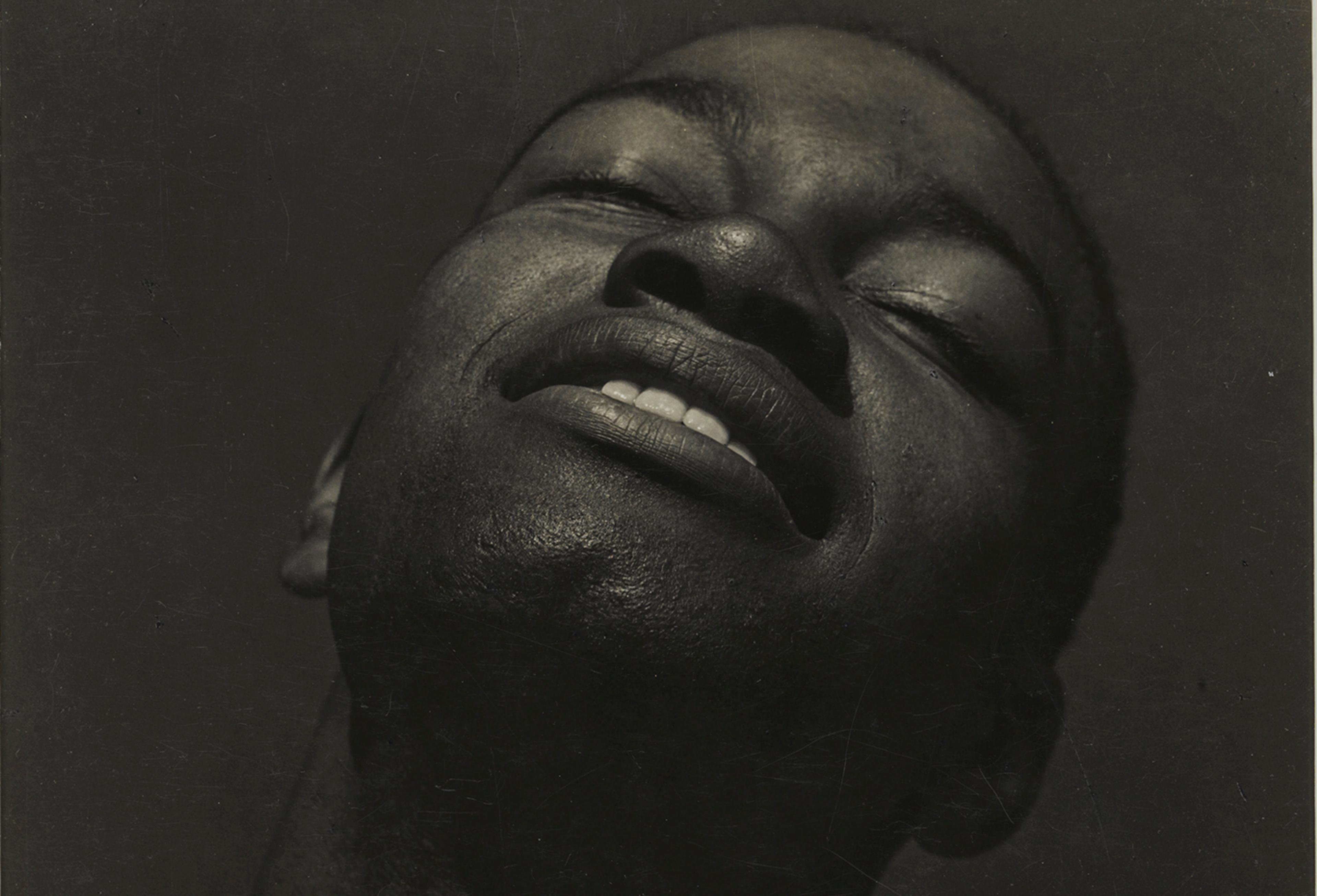 Black-and-white portrait of a man tilting his head upward