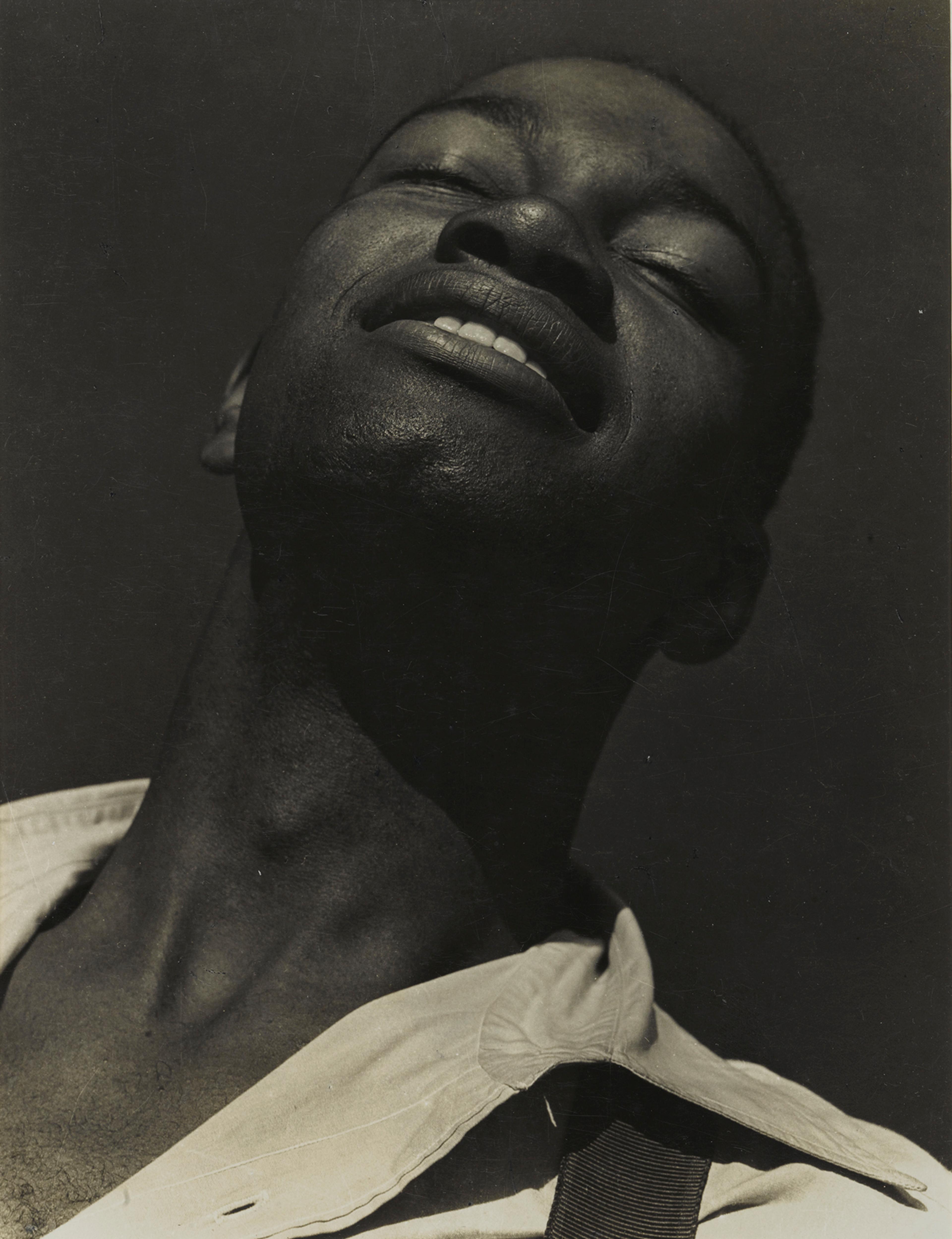 Black-and-white portrait of a man tilting his head upward