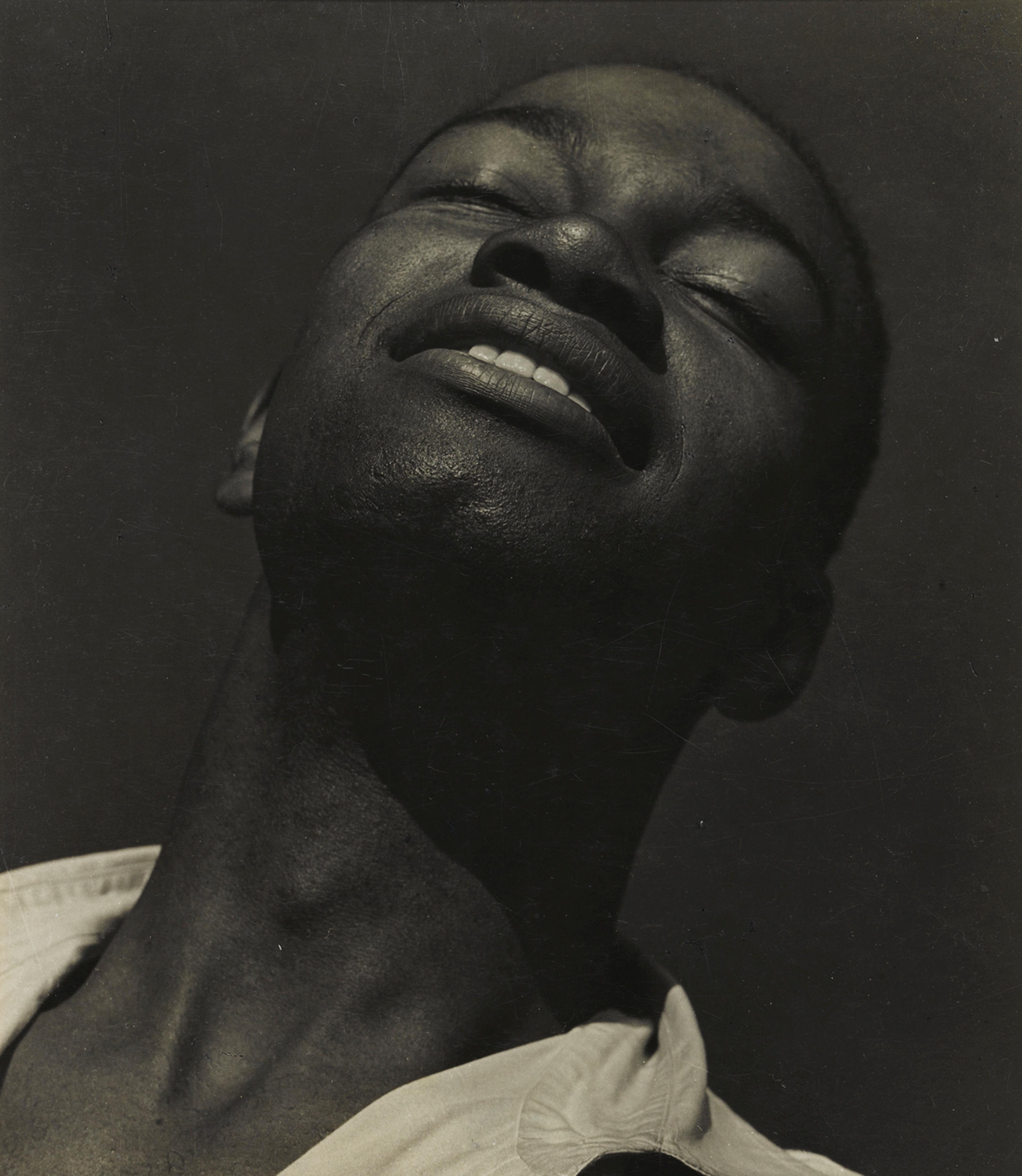 Black-and-white portrait of a man tilting his head upward