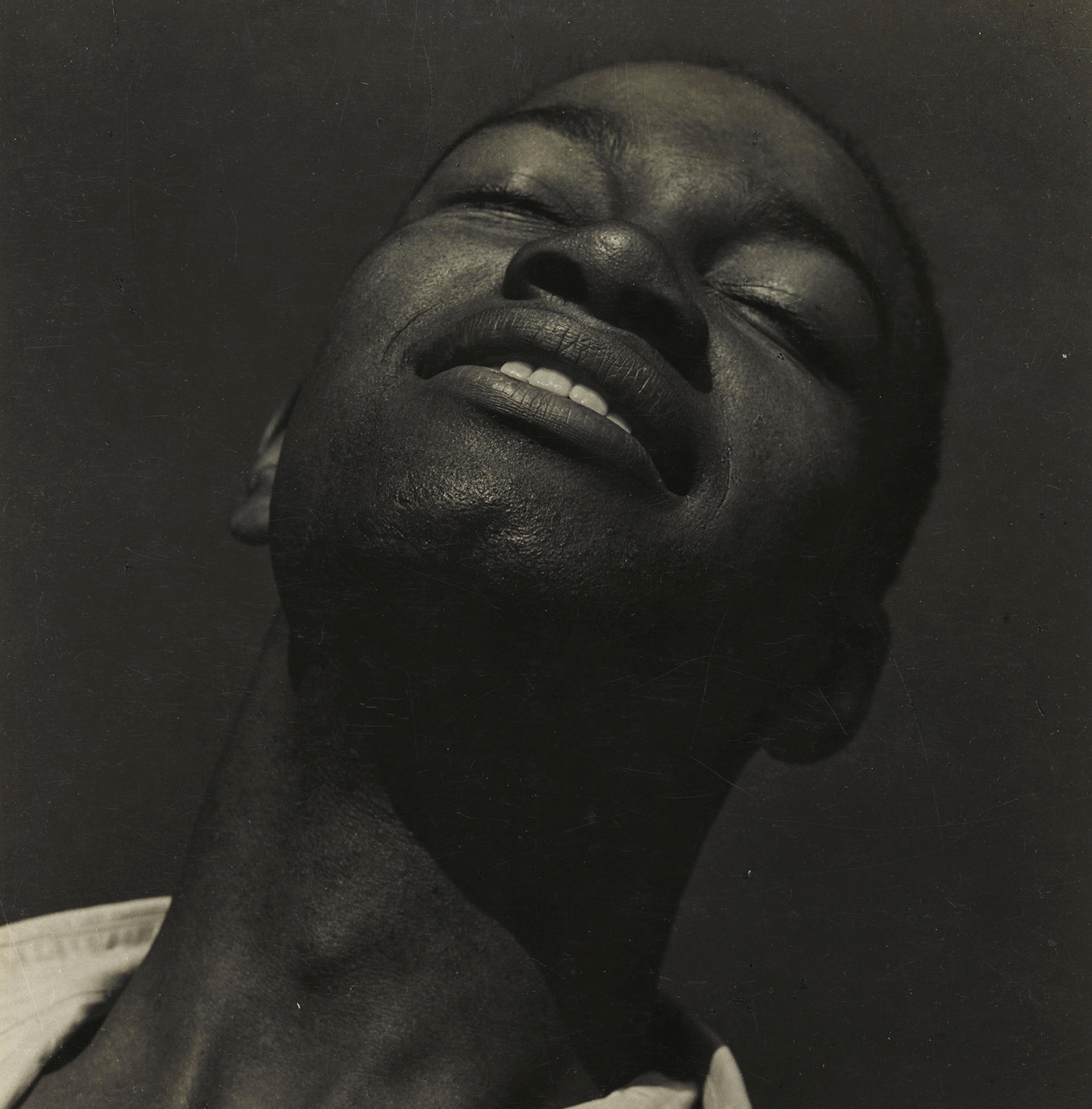 Black-and-white portrait of a man tilting his head upward