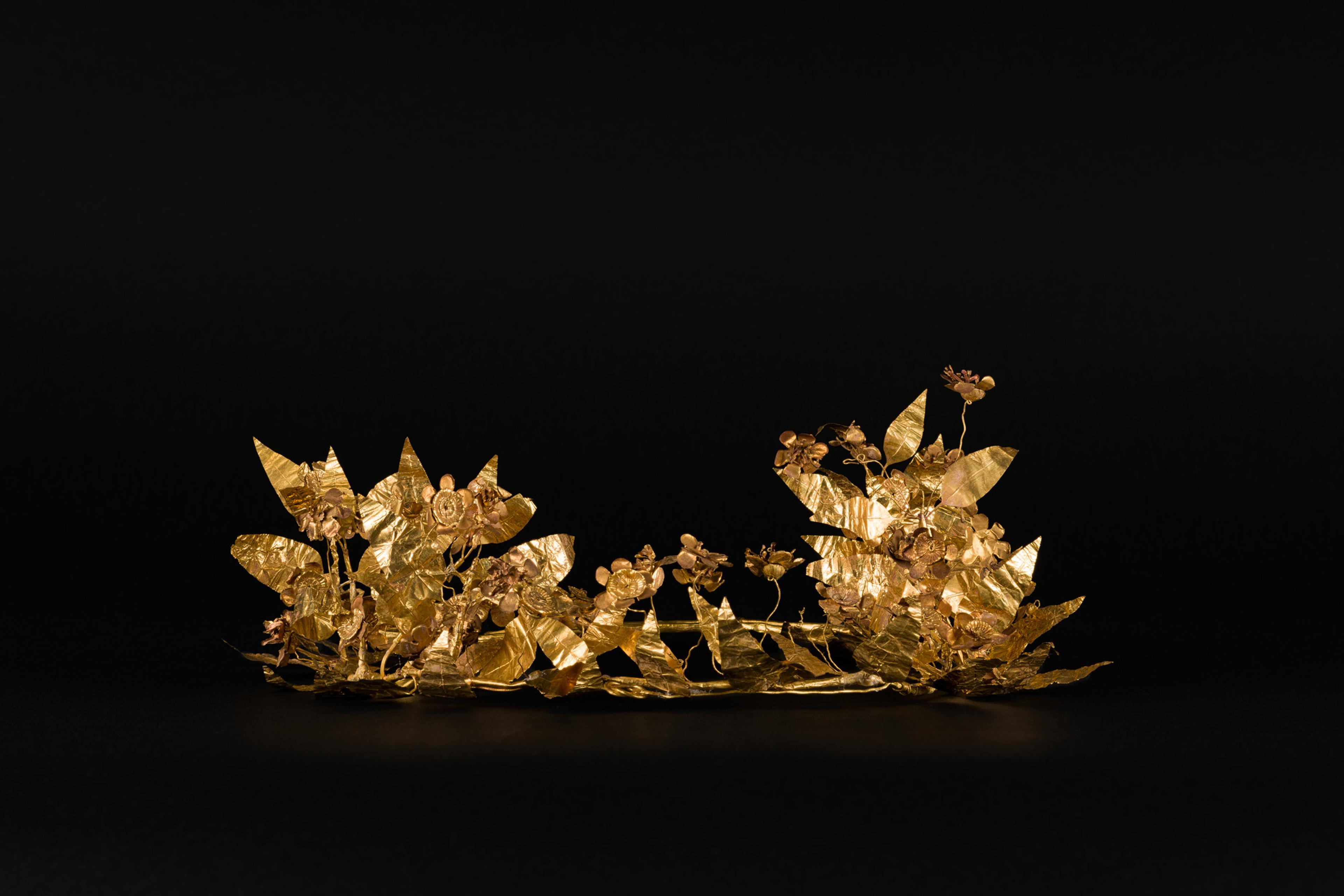 A delicate gold wreath set on a black background