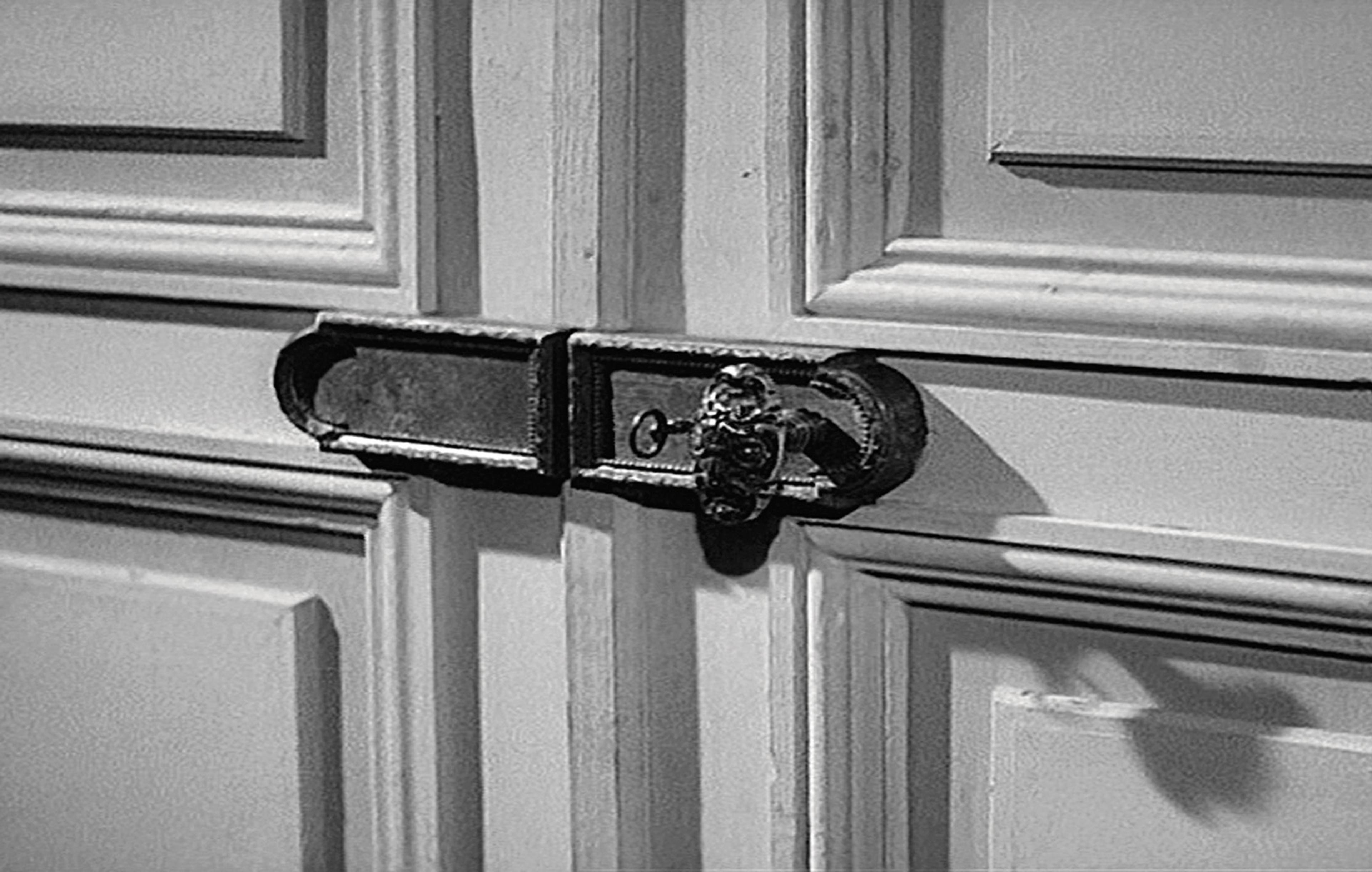Film still showing an elaborate door lock