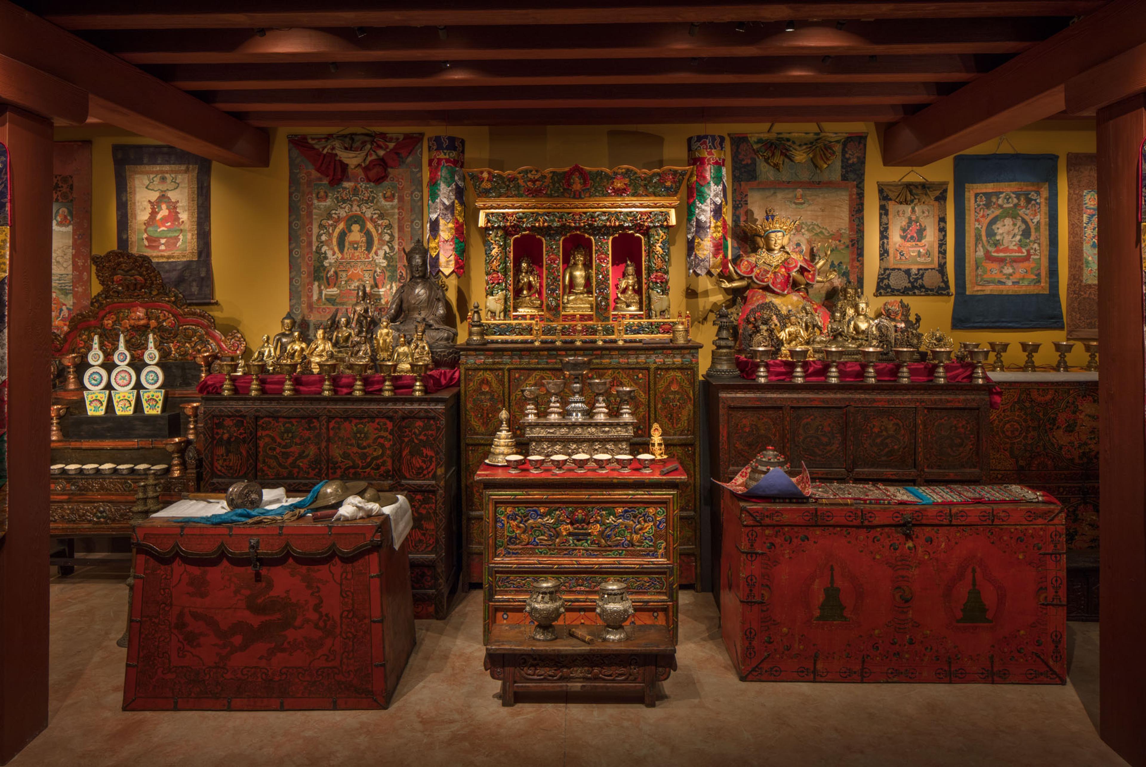Tibetan Buddhist shrine room displaying sculptures, thangkas, and ritual objects