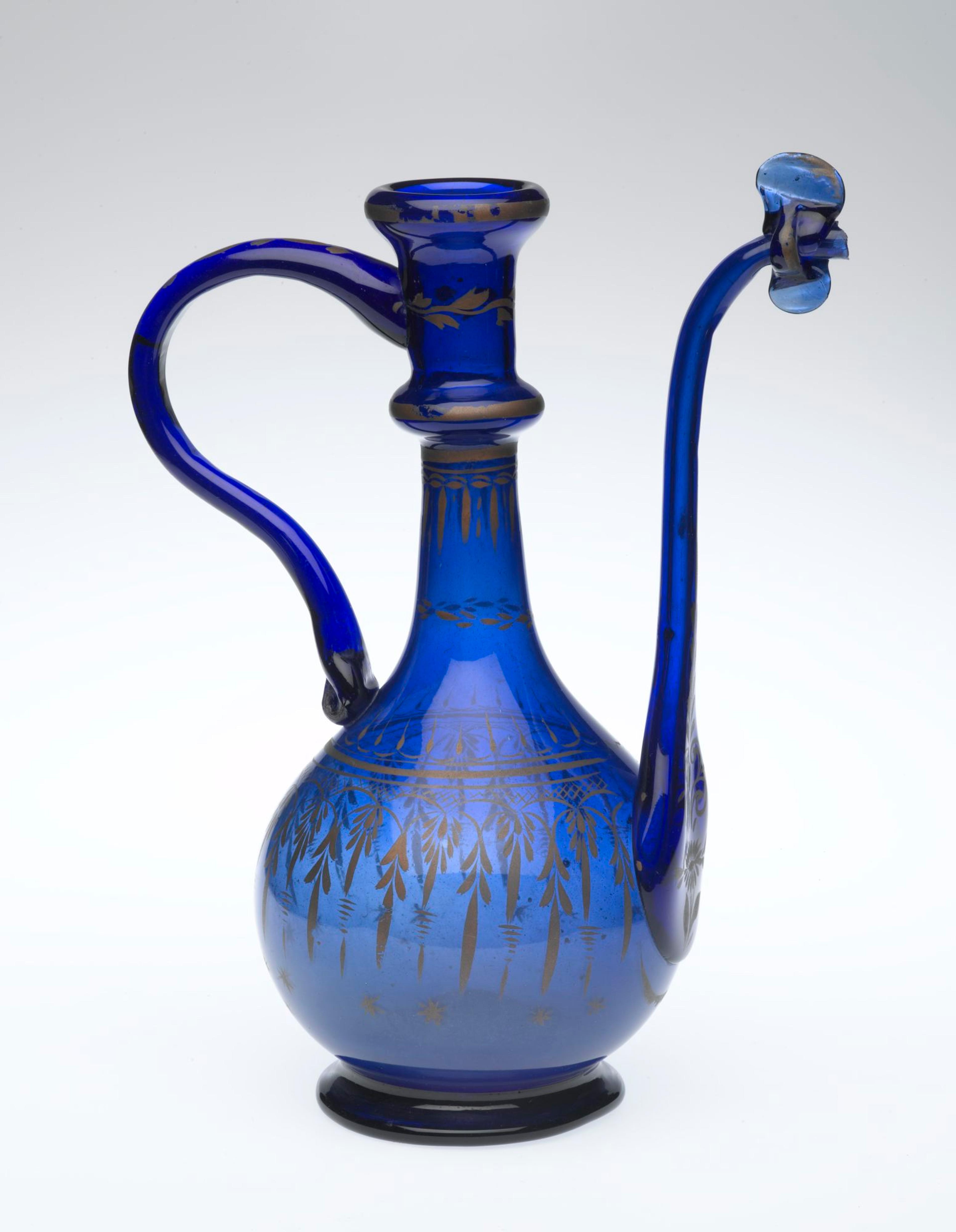 Ewer, Iran, Qum, Qajar period, 19th century. Glass; free-blown, applied, pinched, gilded; tooled on the pontil, 10 1/4 × 7 1/2 × 4 5/16 in. (26 × 19 × 11 cm). Brooklyn Museum; Henry L. Batterman Fund, 47.203.19. (Photo: Brooklyn Museum)