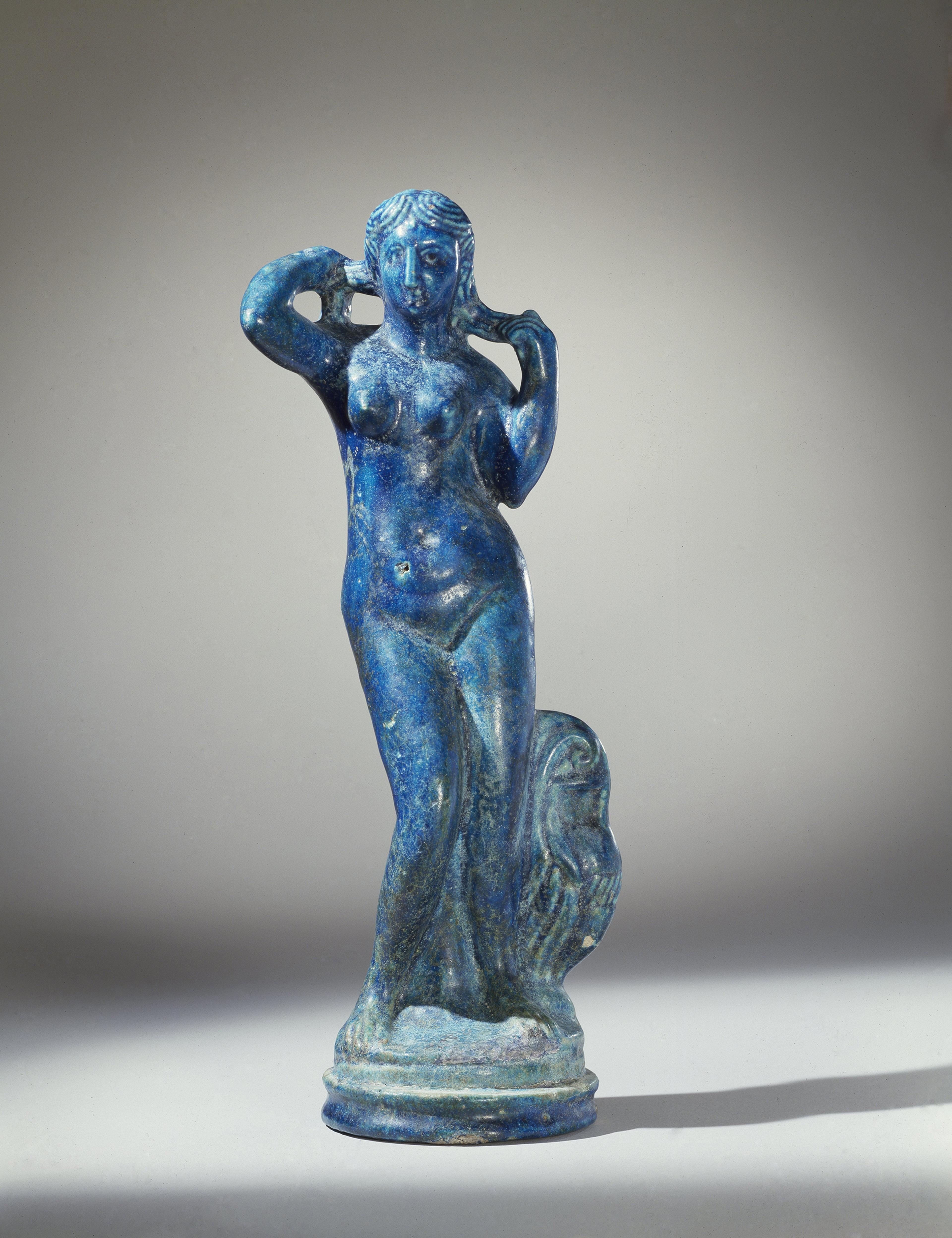 Statuette of Aphrodite Anadyomene. Possibly from Thebtynis, Egypt; Ptolemaic Period, late 2nd century B.C.E. Faience, height: 143/16 in. (36 cm); diameter: 41/4 in. (10.8 cm). Brooklyn Museum; Charles Edwin Wilbour Fund, 44.7. (Photo: Brooklyn Museum)