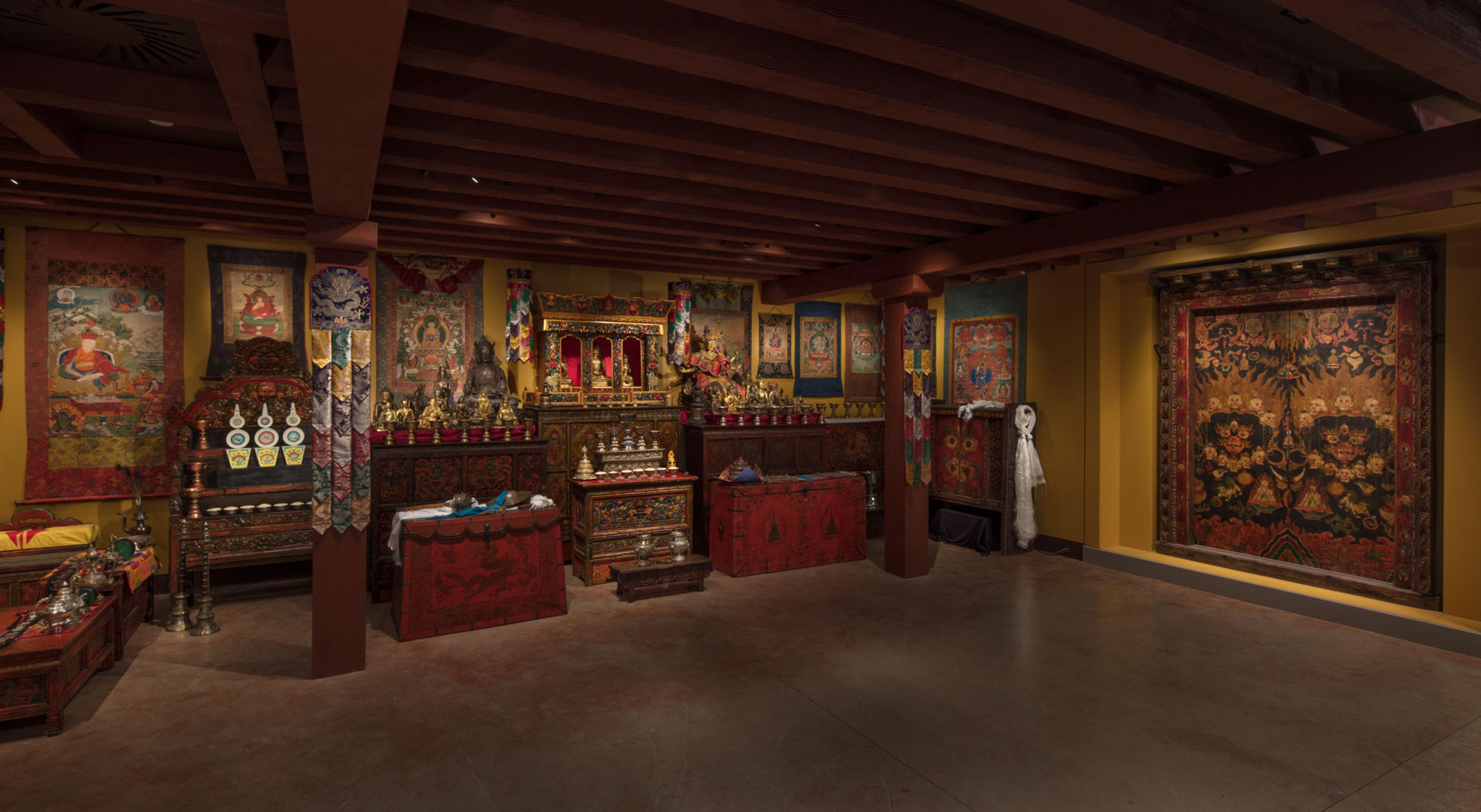 Tibetan Buddhist shrine room displaying sculptures, thangkas, and ritual objects