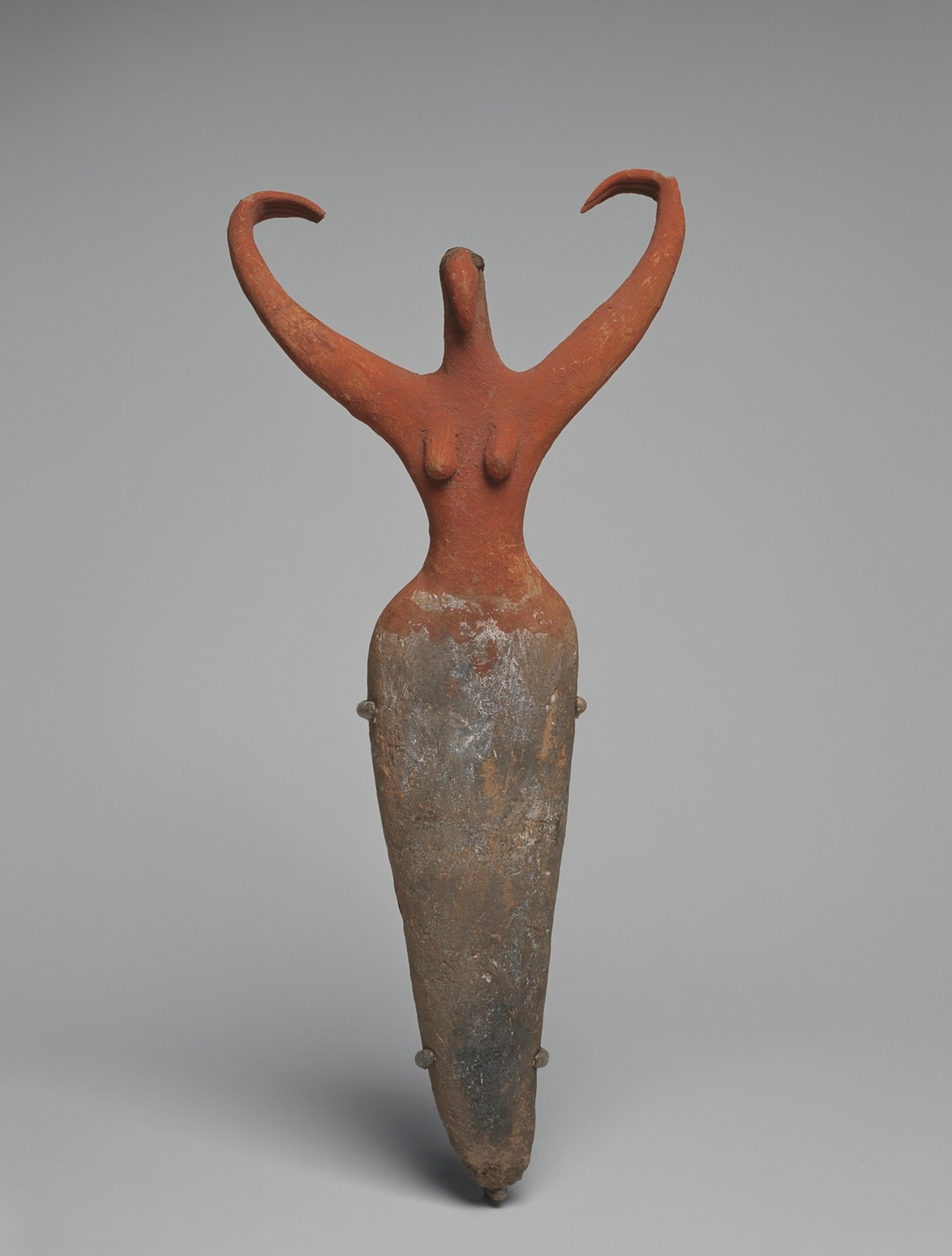 Photograph of a sculpture of a female figure with raised arms