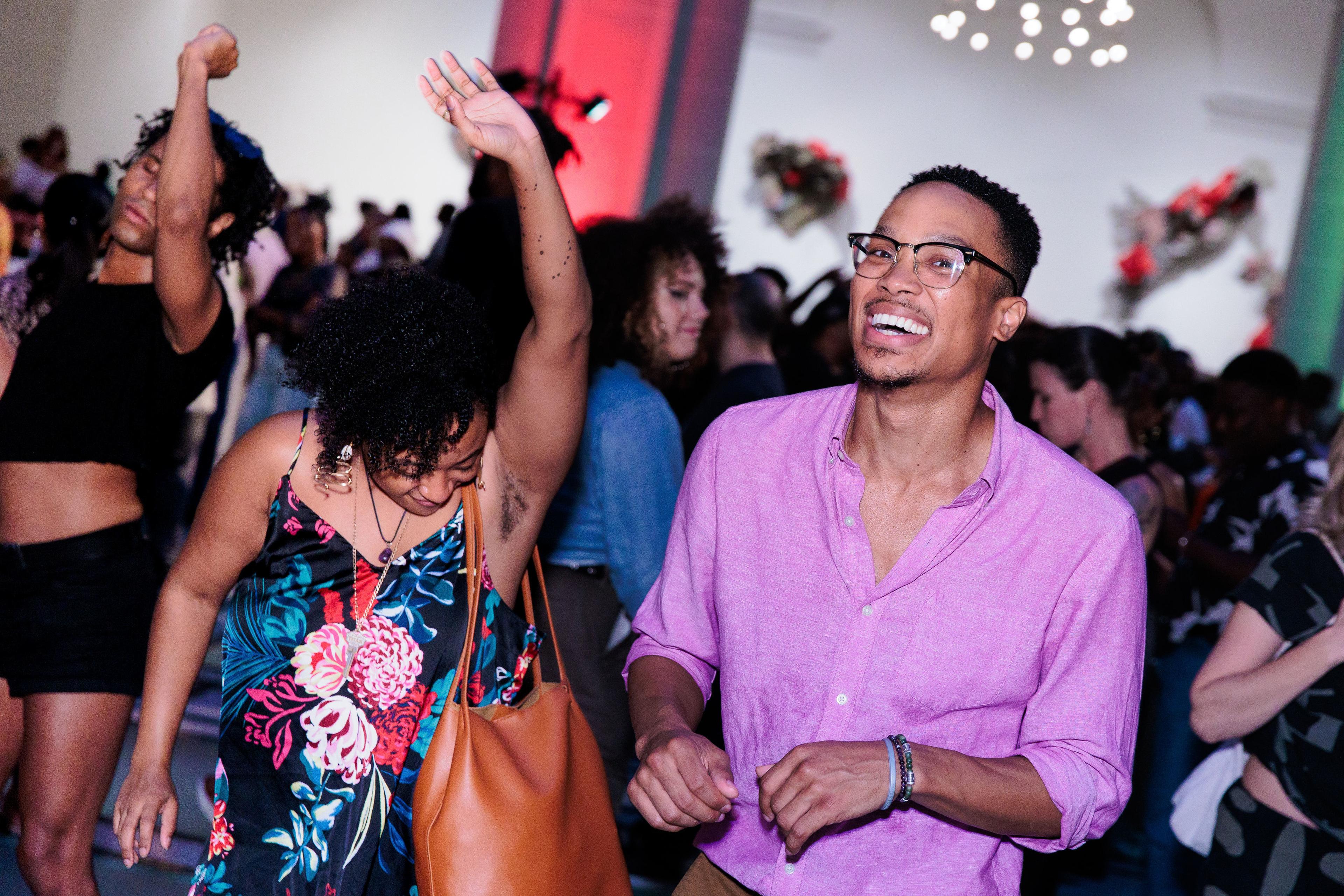People smiling and dancing at a lively indoor party