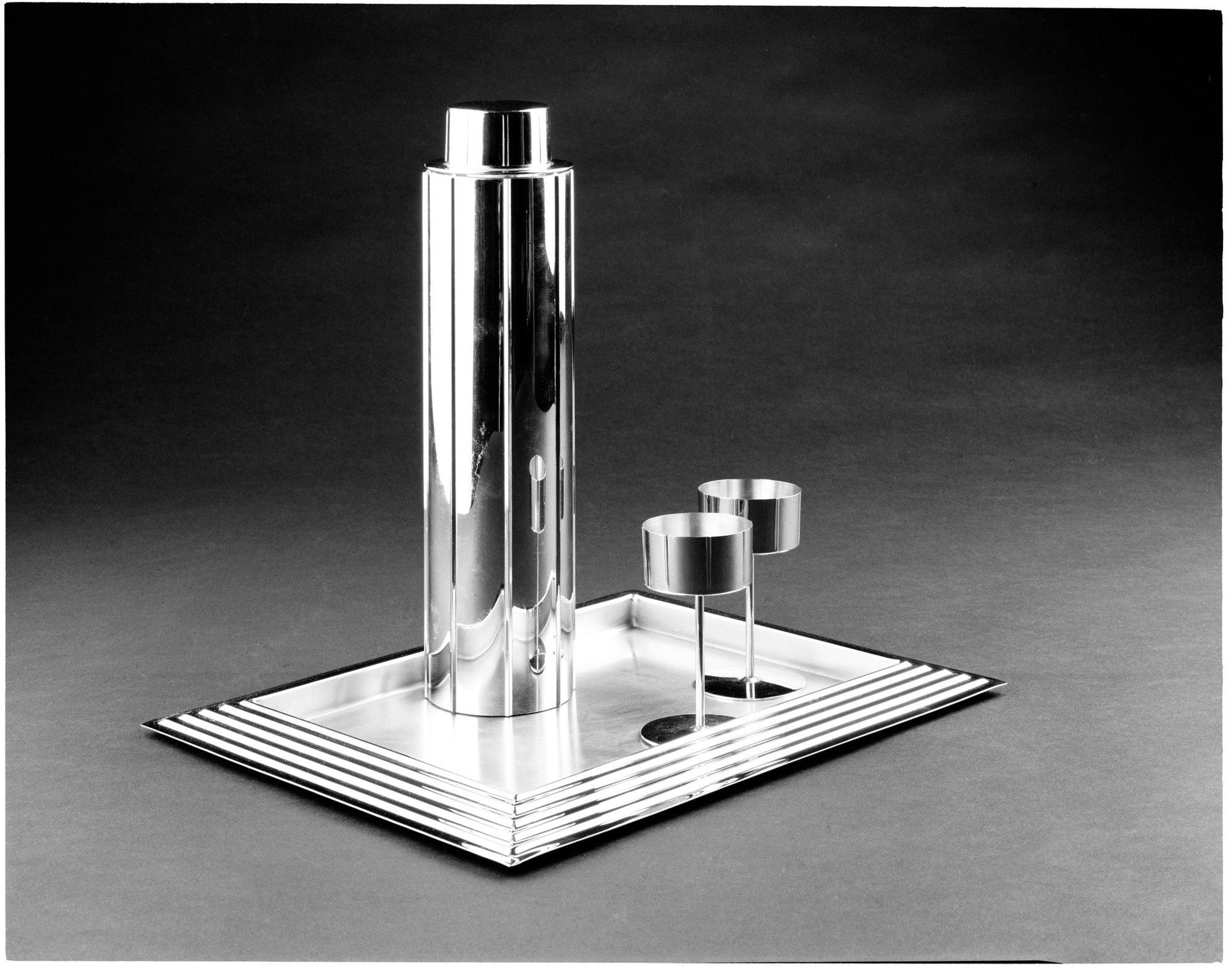 Norman Bel Geddes, designer (American, 1893–1958). Revere Copper and Brass Company, manufacturer, Rome, New York (founded 1928). "Skyscraper" Cocktail set and serving tray, designed 1934, manufactured 1935. Chrome-plated metal, 123/4 × 35/16 × 35/16 in. (32.4 × 8.4 × 8.4 cm). Gift of Paul F. Walter, 83.108.5a-c, .6, .14. (Photo: Brooklyn Museum)