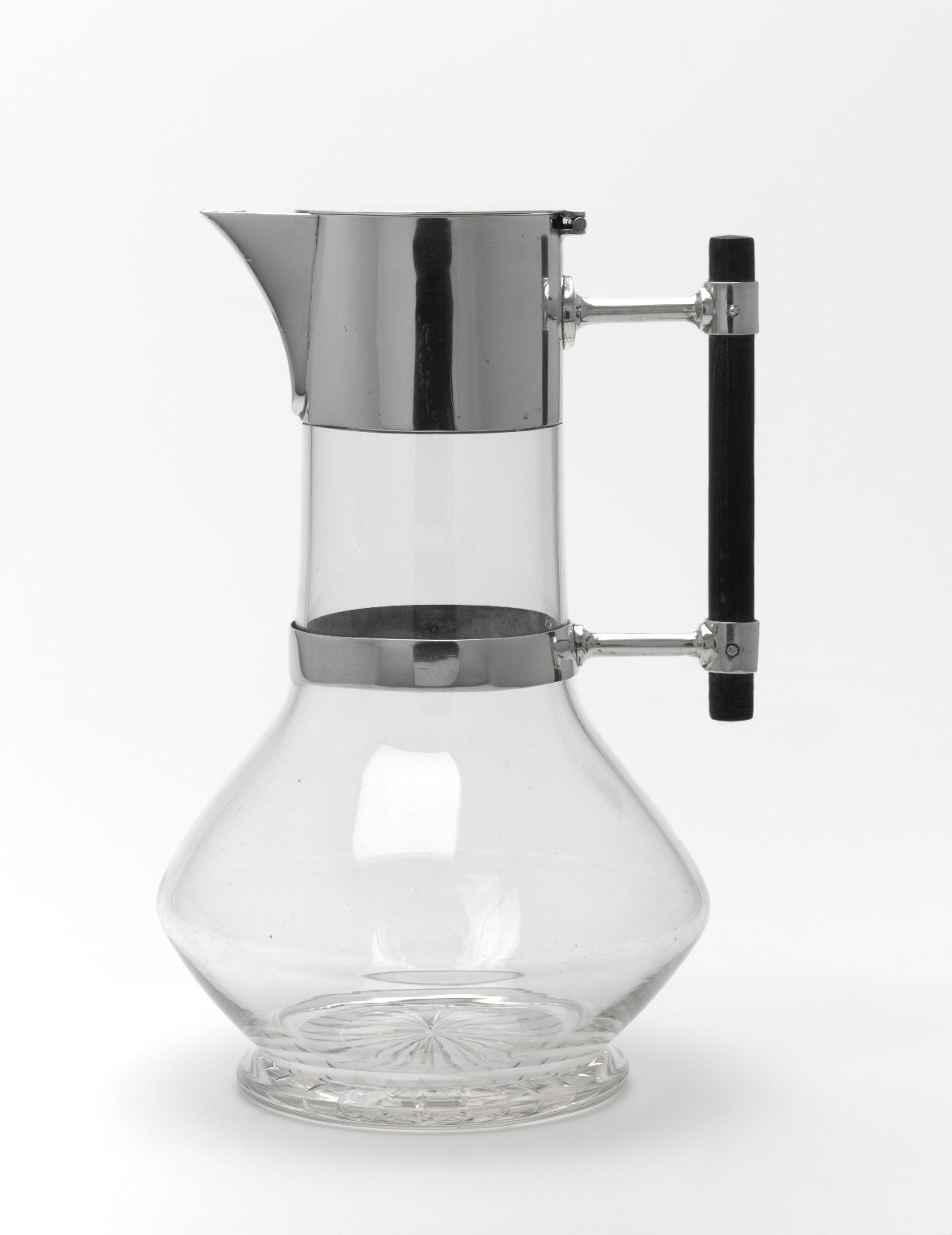 A sleek glass and metal pitcher with a modernist design