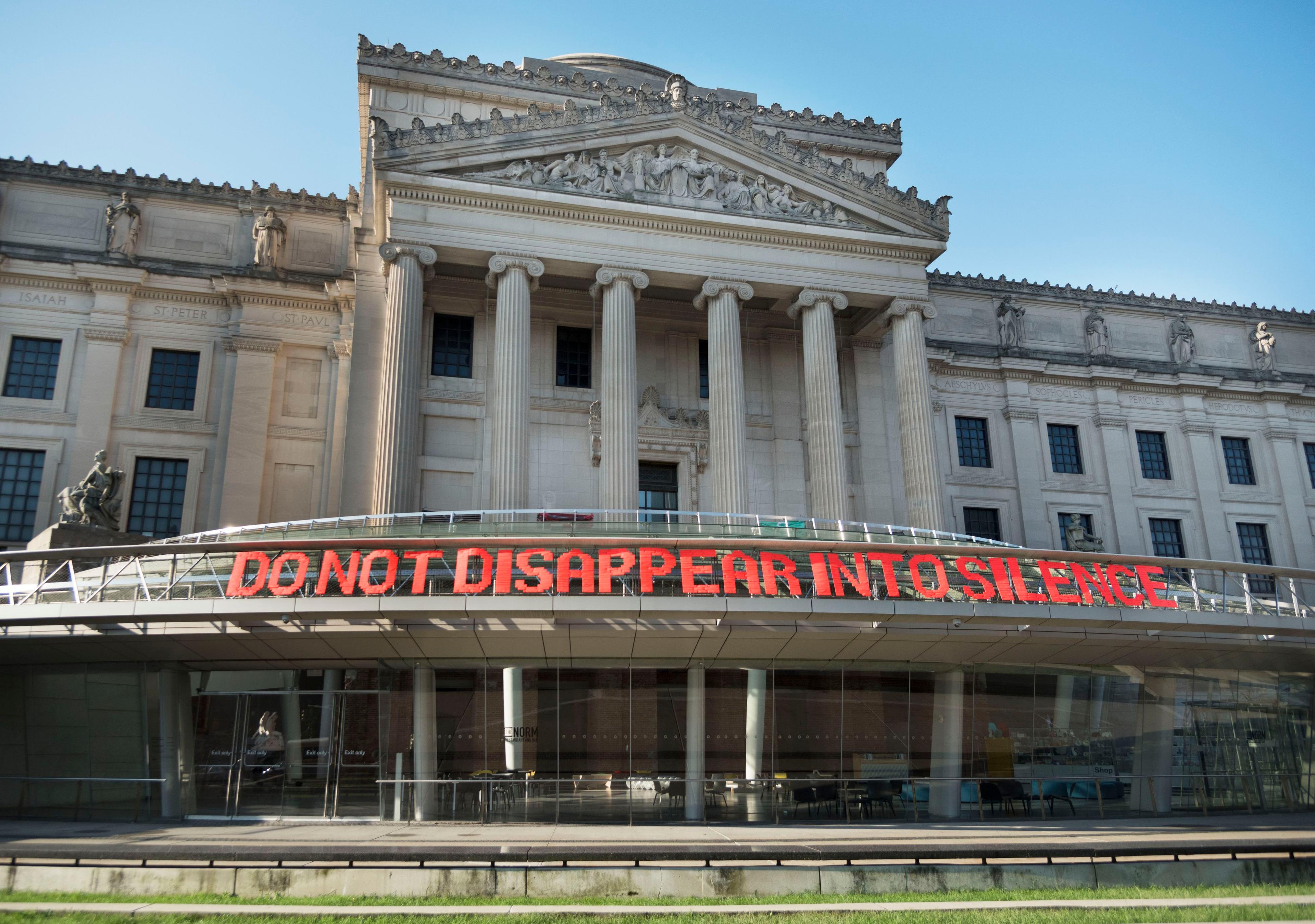 Brooklyn Hi-Art! Machine (established 2010; Mildred Beltré and Oasa DuVerney). DO NOT DISAPPEAR INTO SILENCE, 2014/18. Ribbon, PVC-coated galvanized steel fence, 1200 x 36 in. (3048 x 91.4 cm). Courtesy of Brooklyn Hi-Art! Machine. (Photo: Jonathan Dorado)
