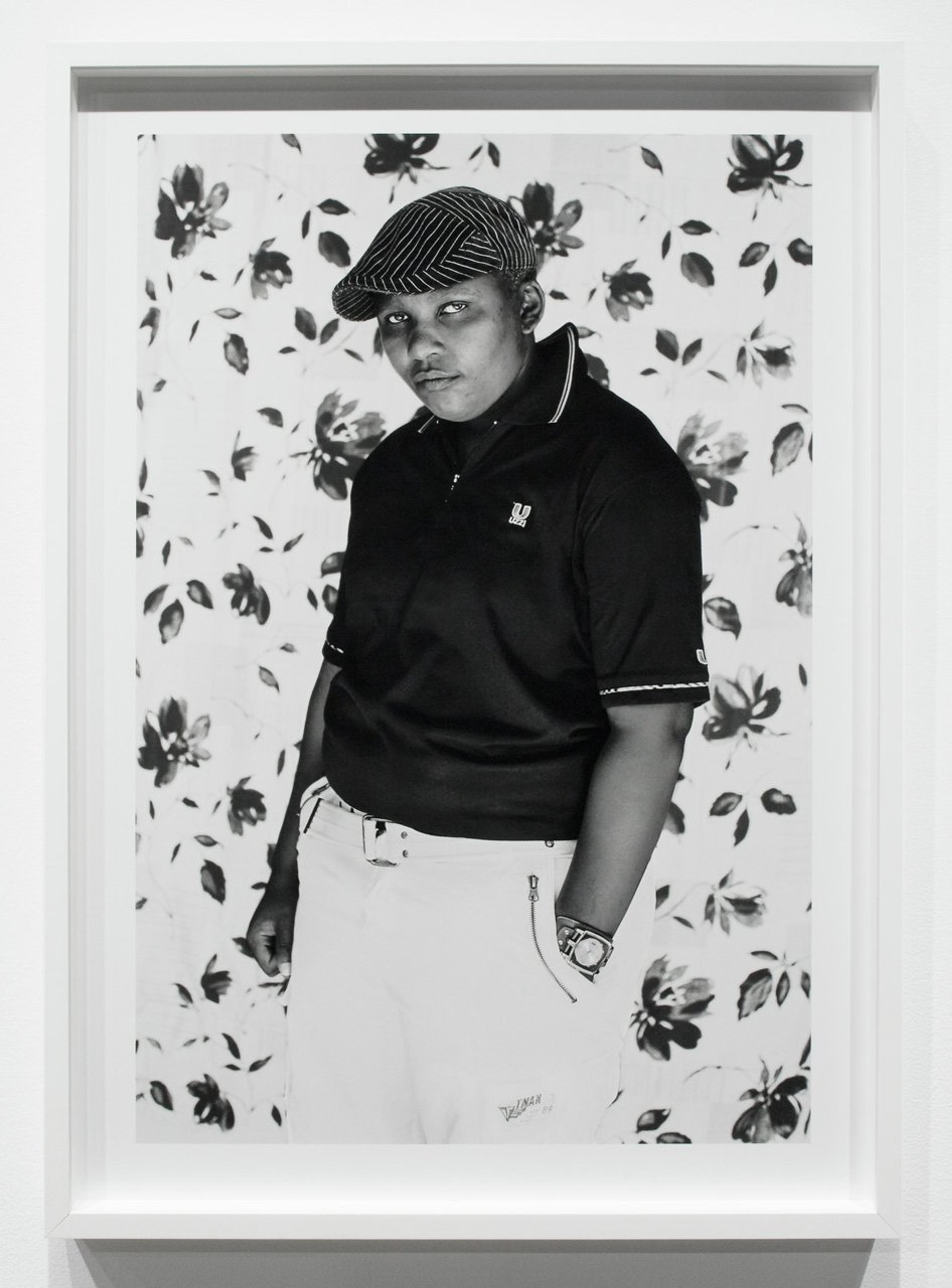 Black-and-white photograph of a boy wearing a cap