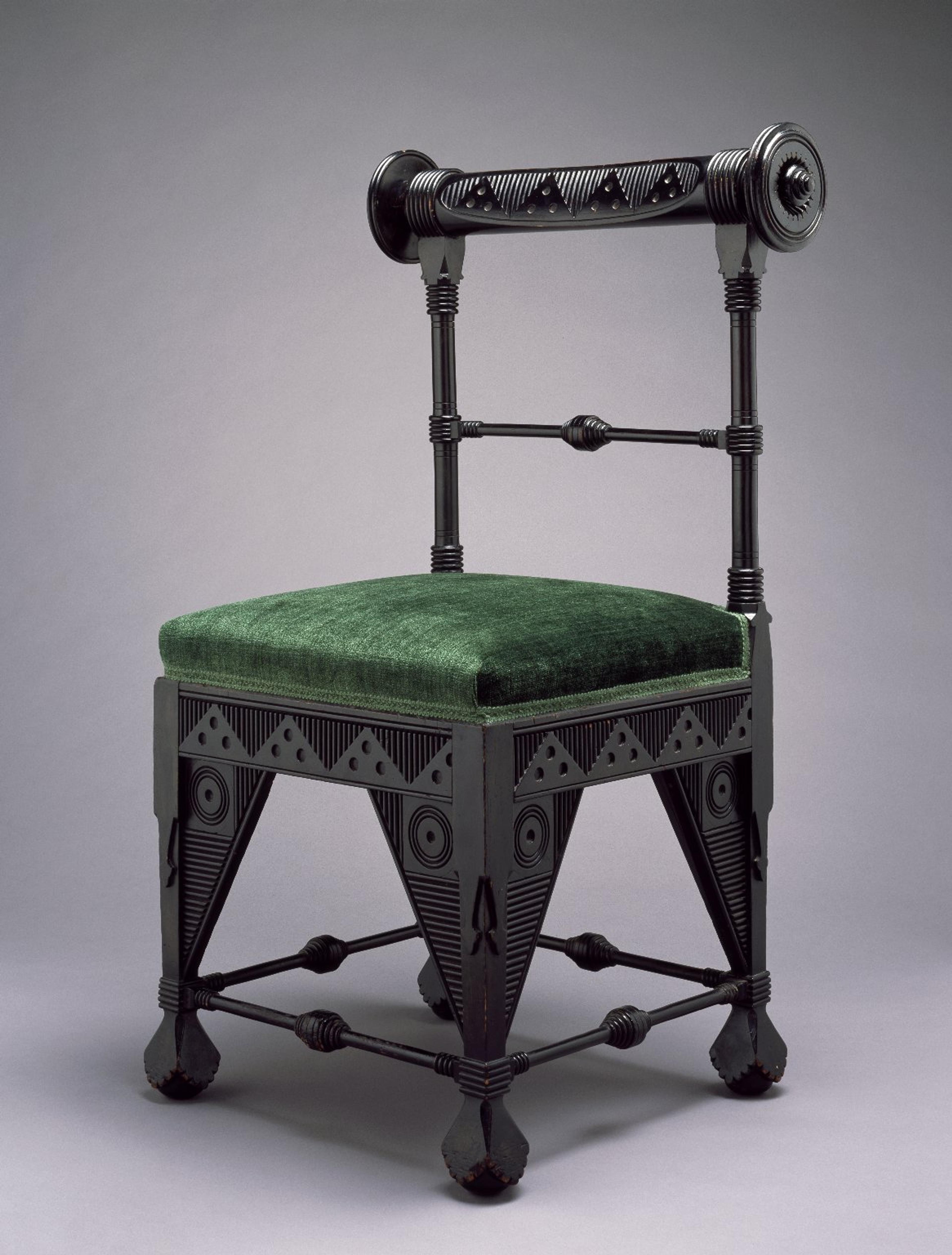 A highly decorative chair with a green upholstered seat