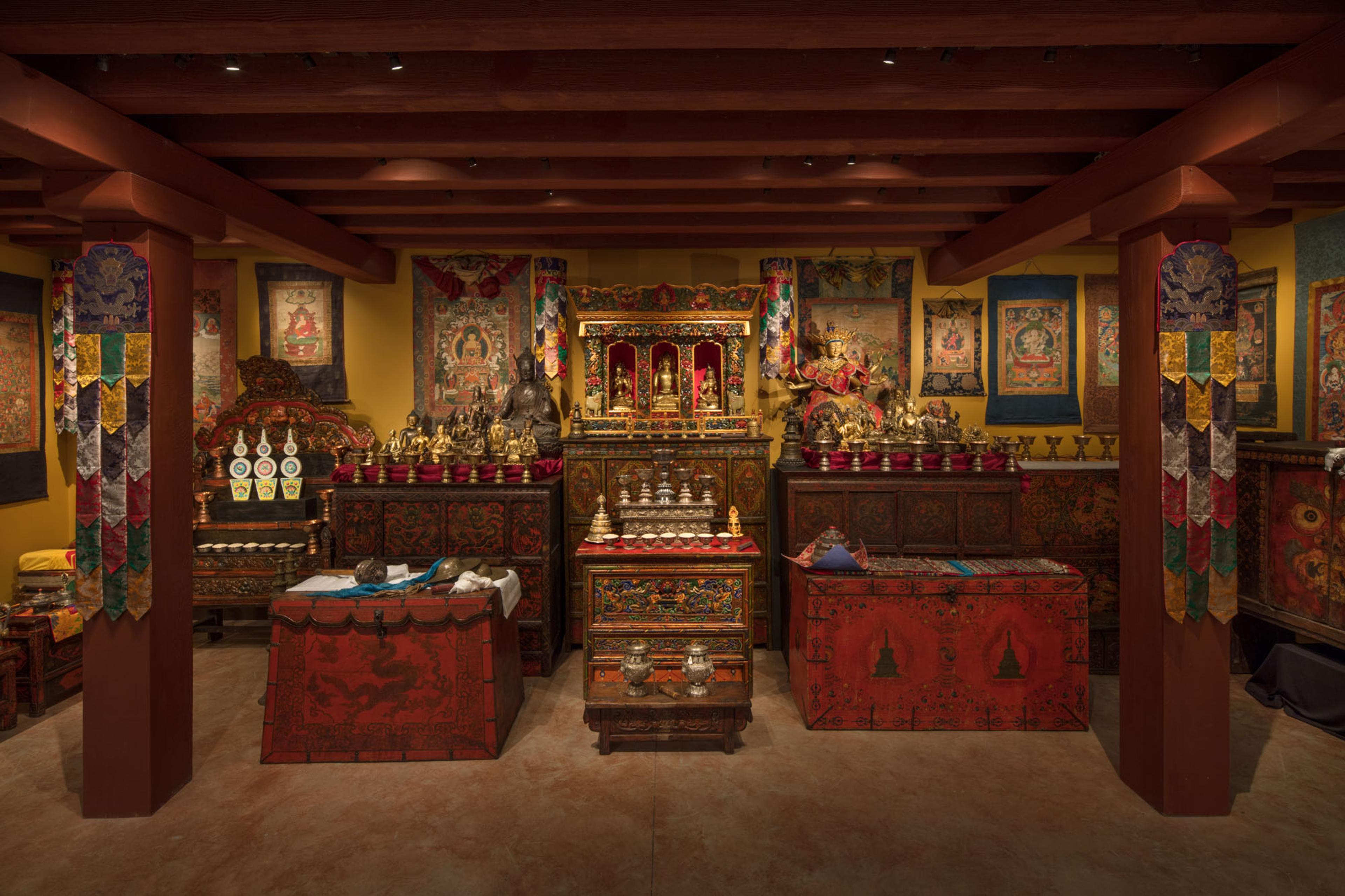 Tibetan Buddhist shrine room displaying sculptures, thangkas, and ritual objects