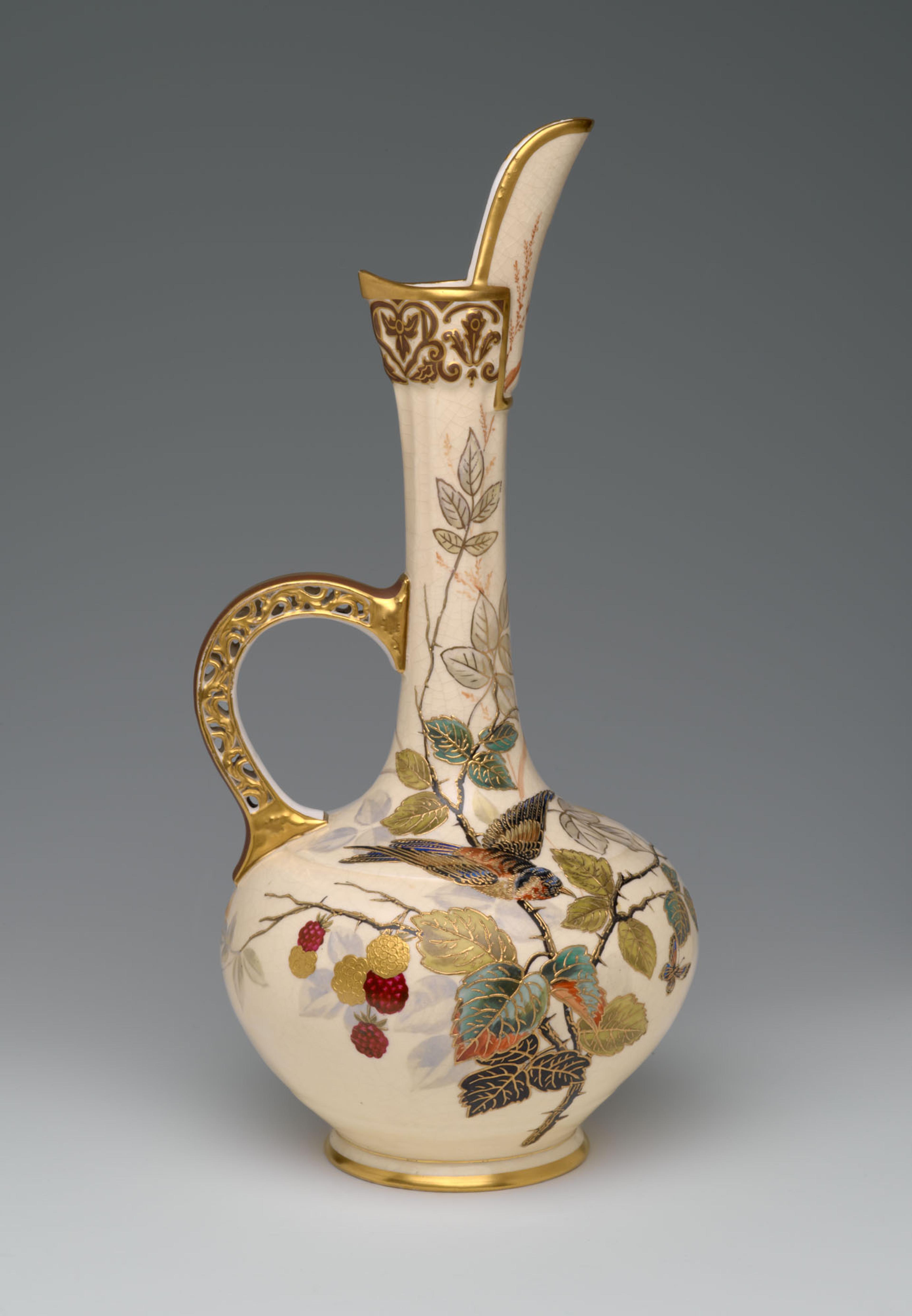 A decorative ceramic ewer with intricate gold detailing