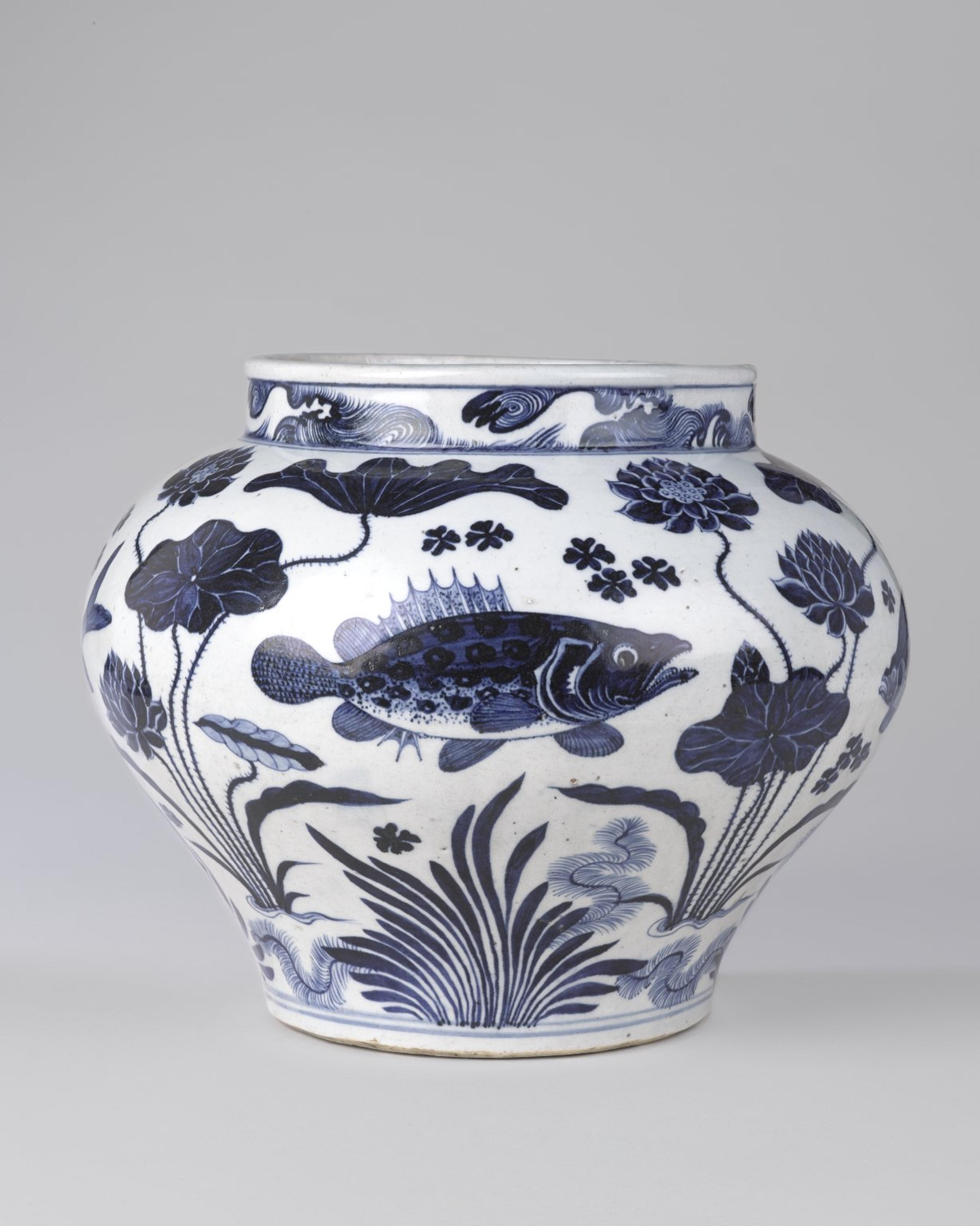 A historical, Chinese, porcelain jar decorated with realistic images of fish and aquatic plants rendered in dark, cobalt blue on a white background