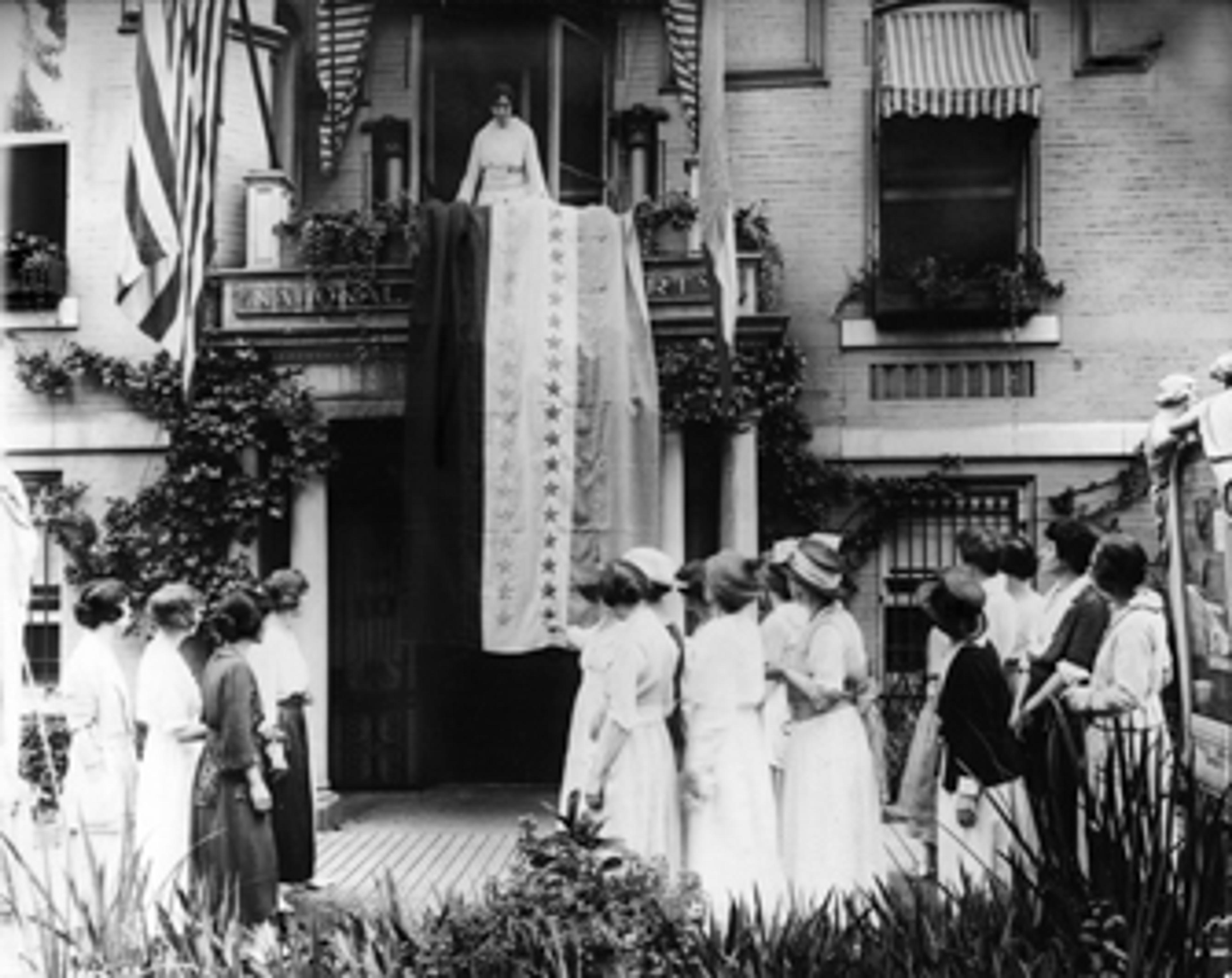 Unknown photographer. Alice Paul Unfurls the Ratification Flag at National Woman’s Party Headquarters in Celebration When Tennessee Became the 36th State to Ratify the Federal Suffrage Amendment, 1920. Albumen silver print. Collection of the historic National Woman’s Party, the Sewall-Belmont House and Museum, Washington, D.C.