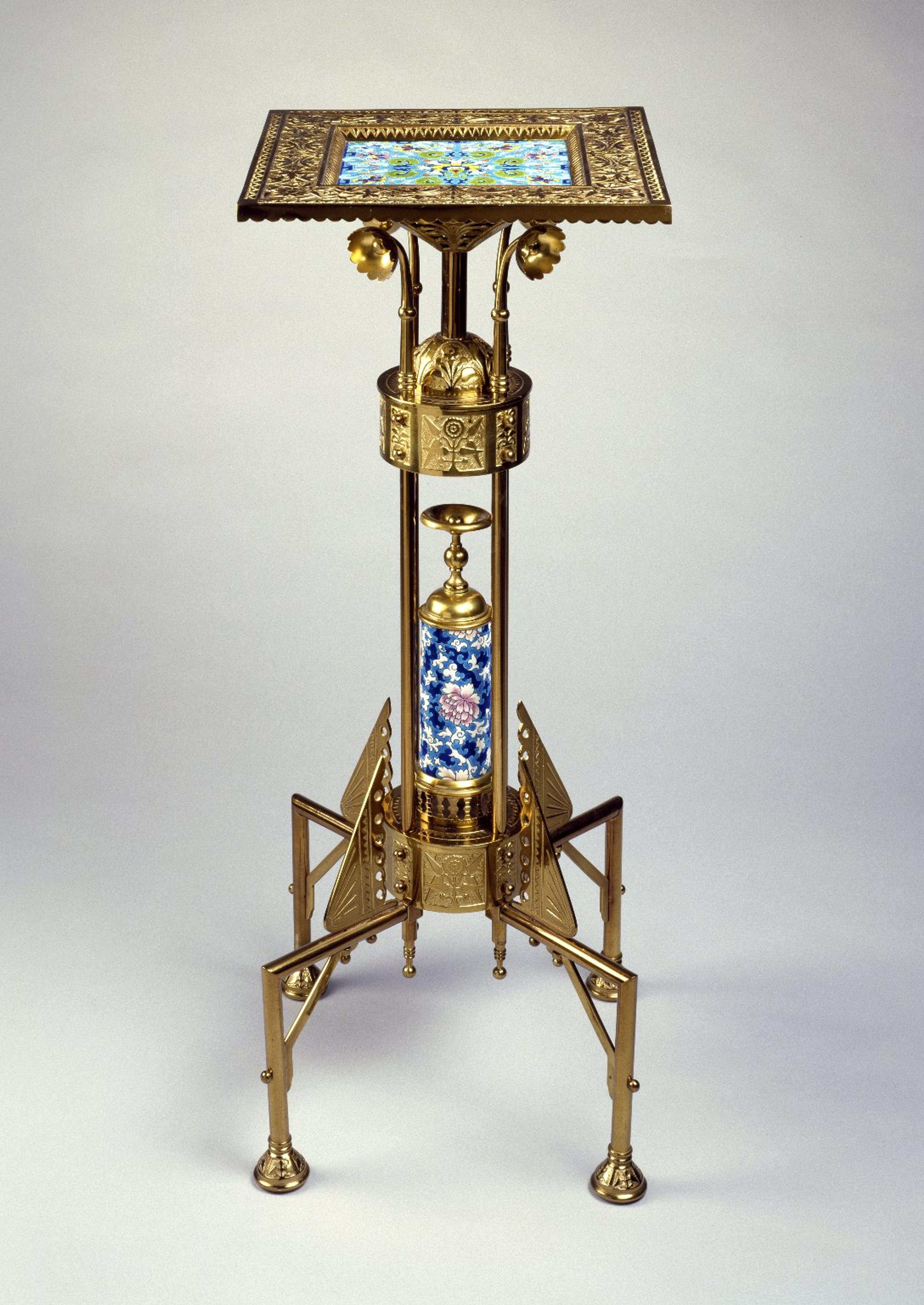 An elaborate gilt metal pedestal table featuring intricate detailing