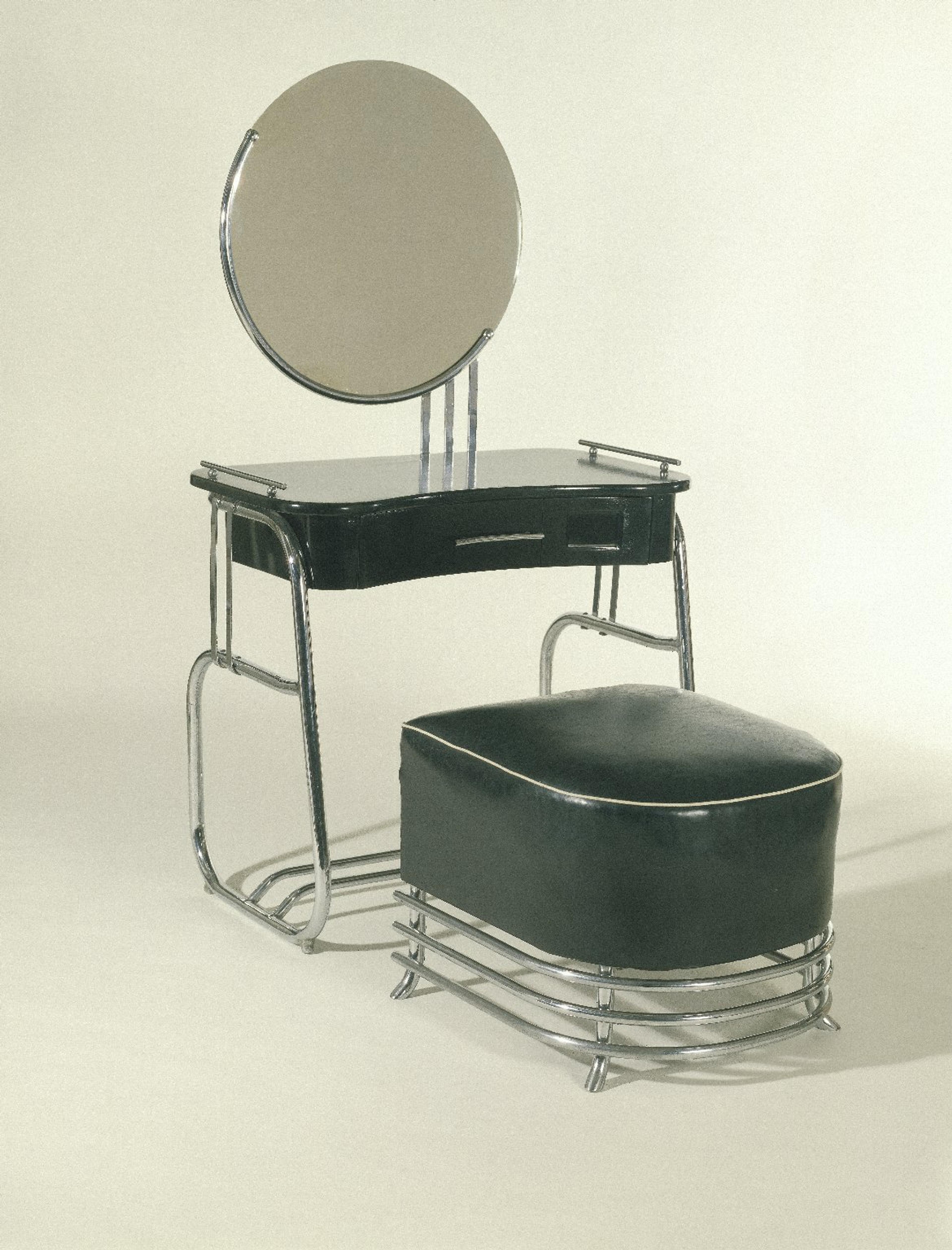 Vanity with Mirror and Stool. Kem Weber (American, b. Germany, 1889–1963). Made by Lloyd Manufacturing Company. Menominee, Michigan, 1934. Chrome-plated tubular steel, wood, glass, upholstery, vanity: 55 × 33 × 191⁄2 in. (139.7 × 83.8 × 49.5 cm), stool: 171⁄2 x 21 × 221⁄2 in. (44.5 × 53.3 × 57.2 cm). Brooklyn Museum, Modernism Benefit Fund, 87.123.1a–b and 87.123.2