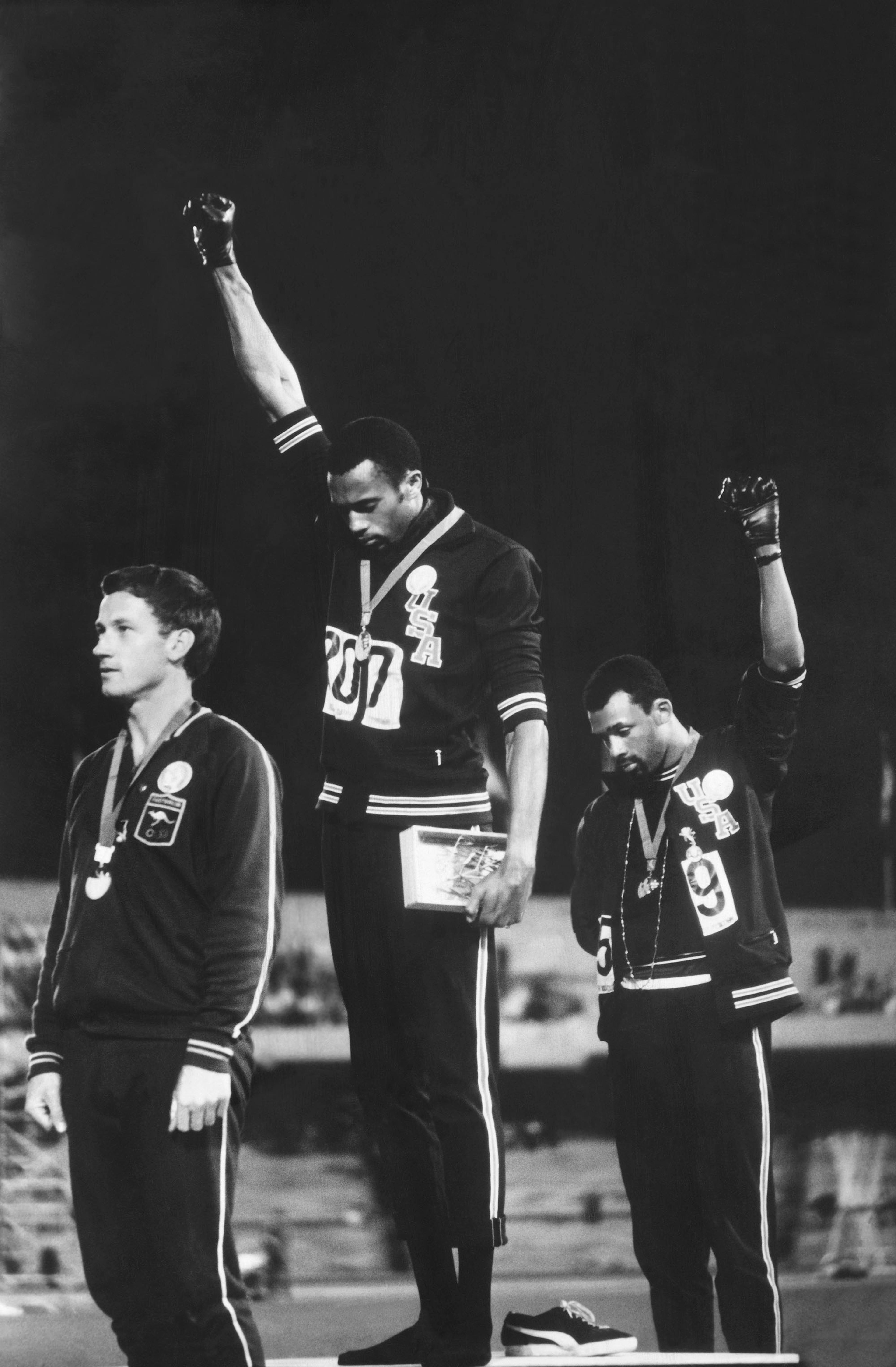 John Dominis (American, 1921–2013). American track and field athletes Tommie Smith (C) and John Carlos (R), first and third place winners in the 200 meter race, protest with the Black Power salute as they stand on the winner's podium at the Summer Olympic games, Mexico City, Mexico, October 19, 1968. Australian silver medalist Peter Norman stands by, 1968; printed 2016. Inkjet print, 14 x 9¼ in. (35.6 x 23.3 cm). Courtesy of John Dominis/Getty Images